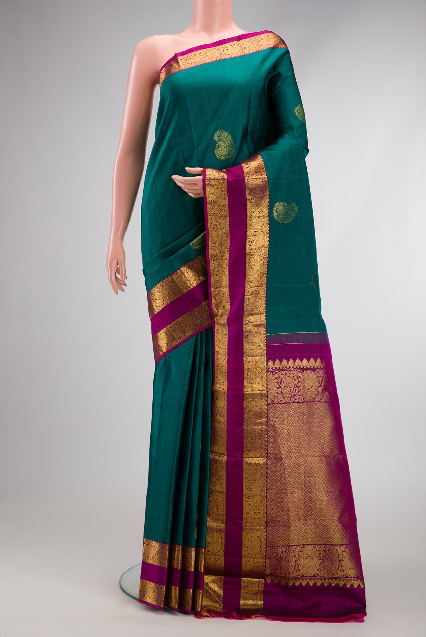 Green Dual Tone Kanjivaram Silk Saree with Zari Butta on the body and Zari Border.  displayed on a mannequin