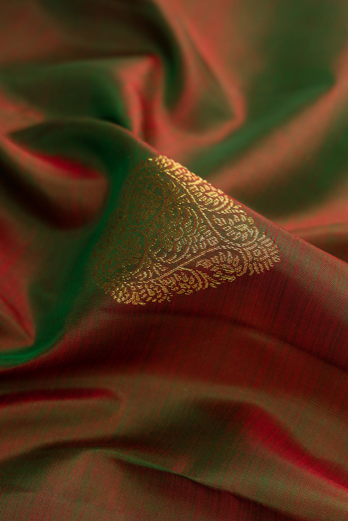 Close up of Mehandi Green Dual Tone Kanjivaram Silk Saree with Zari Butta on the body and Zari Border.  displaying folds
