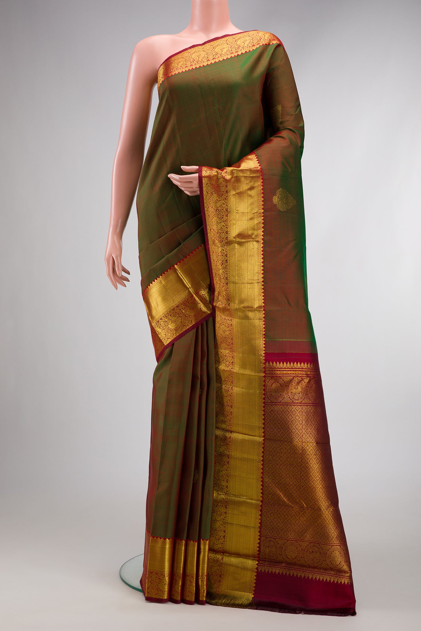 Mehandi Green Dual Tone Kanjivaram Silk Saree with Zari Butta on the body and Zari Border.  displayed on a mannequin