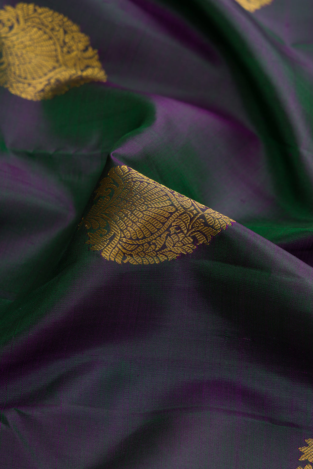 Close up of Bottle Green Dual Tone Kanjivaram Silk Saree with Zari Butta on the body and Zari Border.  displaying folds