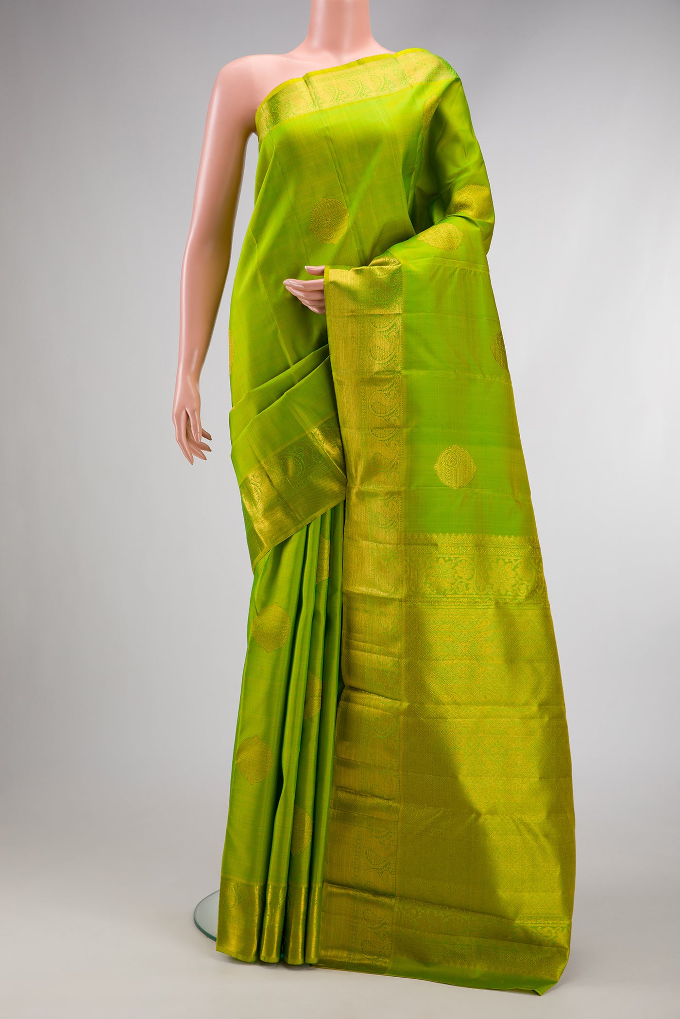 Parrot Green Dual Tone Kanjivaram Silk Saree with Zari Butta on the body and Zari Border.  displayed on a mannequin
