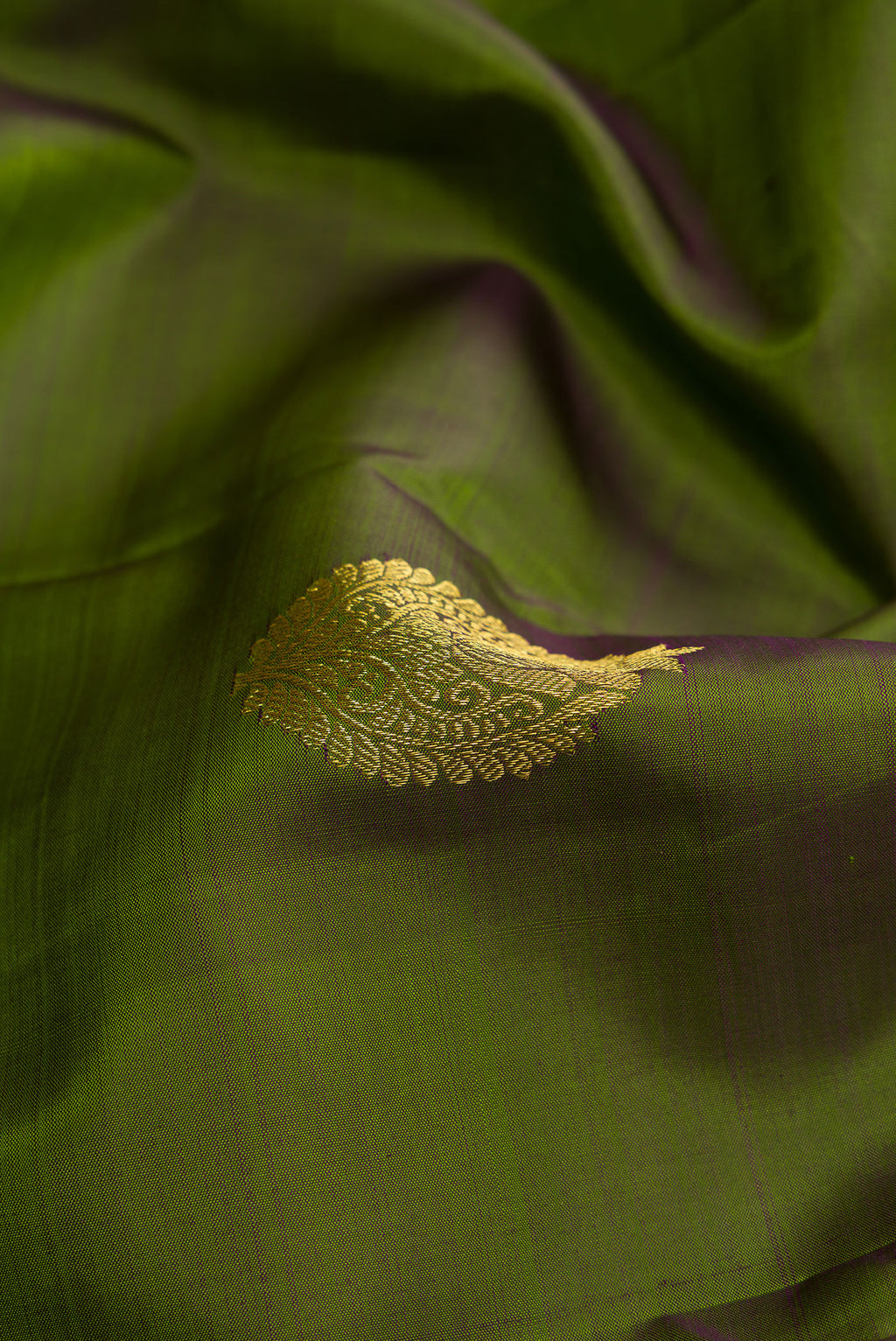 Close up of Magenta Dual Tone Kanjivaram Silk Saree with Zari Butta on the body and Zari Border.  displaying folds