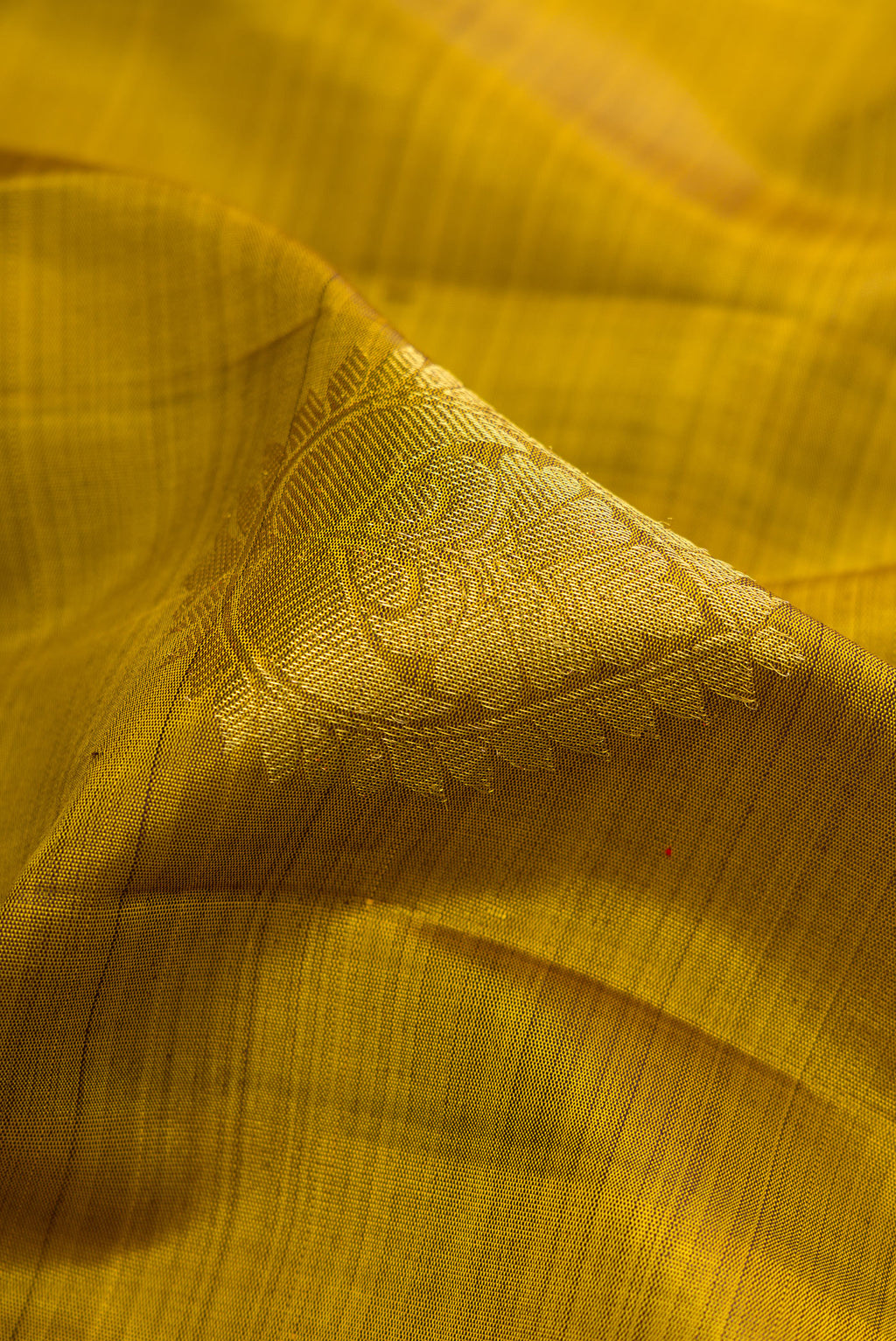 Close up of Mehandi Green Dual Tone Kanjivaram Silk Saree with Zari Butta on the body and Zari Border.  displaying folds