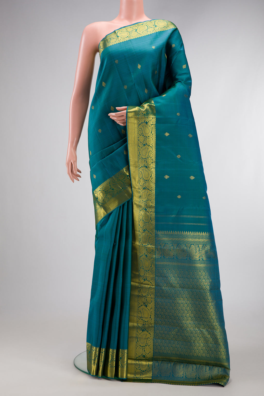 Teal Dual Tone Kanjivaram Silk Saree with Zari Butta on the body and Zari Border.  displayed on a mannequin