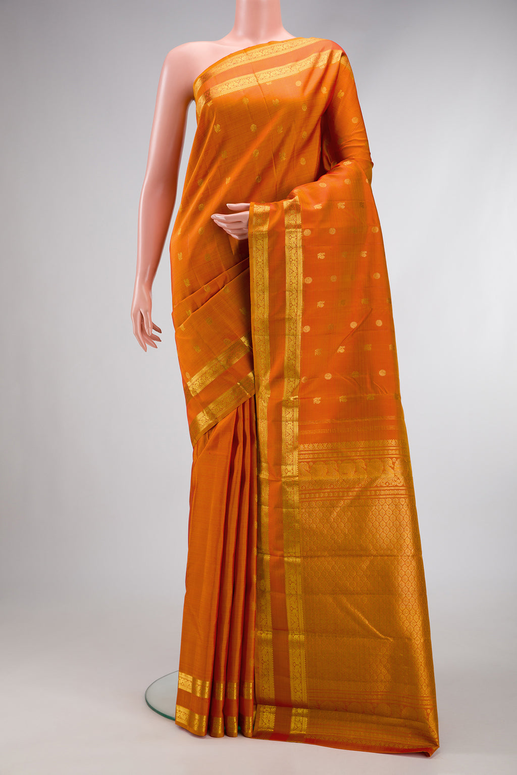 Orange Dual Tone Kanjivaram Silk Saree with Zari Butta on the body and Zari Border.  displayed on a mannequin