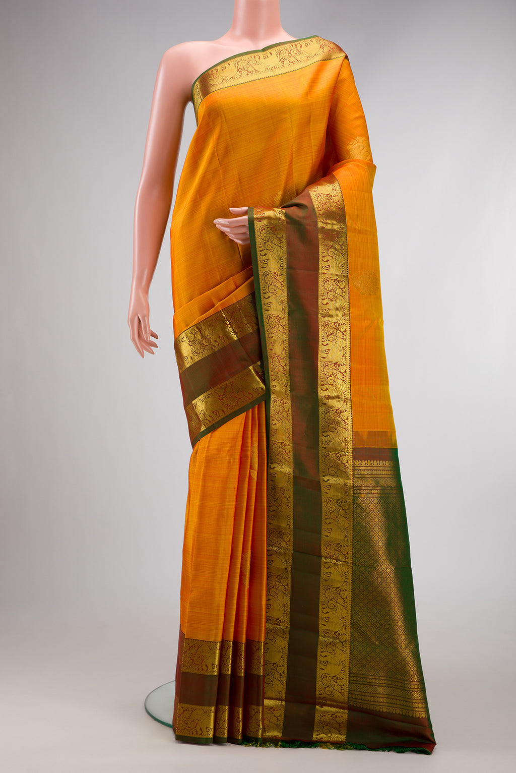 Mustard Dual Tone Kanchipuram Silk Saree with Zari Butta on the body and Zari Border.  displayed on a mannequin