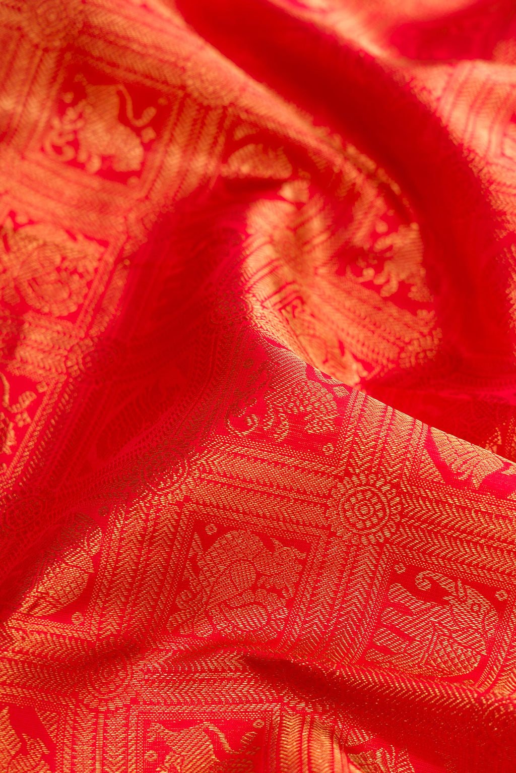 Close up of Pure Silk Pure Zari Red Dual Tone Kanjivaram Saree with Zari Brocade on the body and Zari Border.  displaying folds