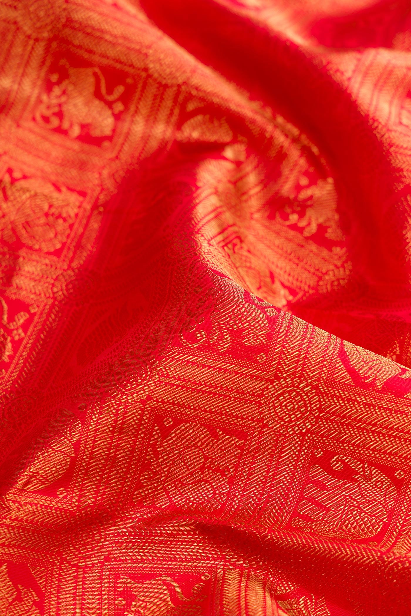 Close up of Pure Silk Pure Zari Red Dual Tone Kanjivaram Saree with Zari Brocade on the body and Zari Border.  displaying folds