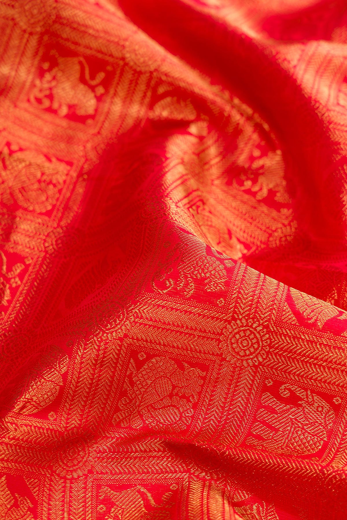 Close up of Pure Silk Pure Zari Red Dual Tone Kanjivaram Saree with Zari Brocade on the body and Zari Border.  displaying folds