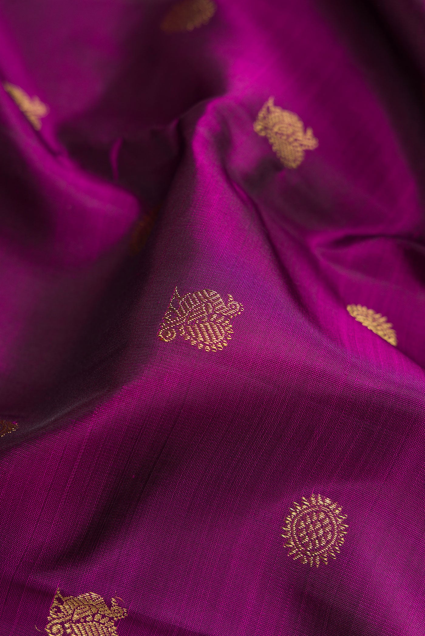 Close up of Pure Silk Pure Zari Purple Dual Tone Kanjivaram Saree with Zari Butta on the body and Zari Border.  displaying folds