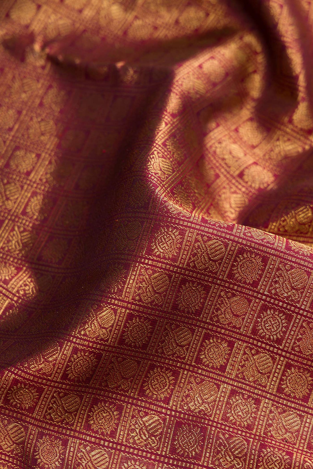 Close up of Pure Silk Pure Zari Maroon Kanjivaram Saree with Zari Brocade on the body and Zari Border.  displaying folds