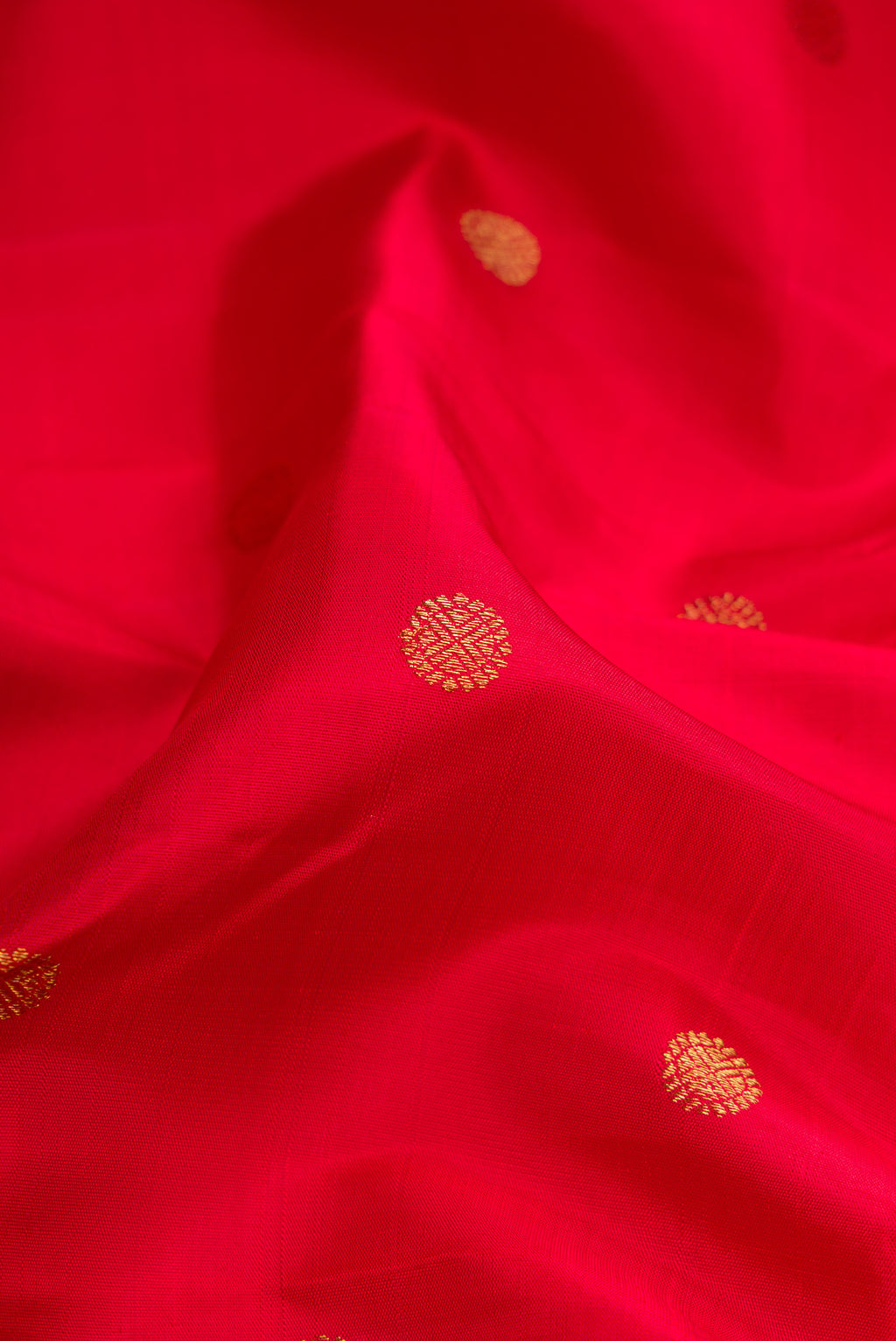 Close up of Red Dual Tone Kanjivaram Silk Saree with Zari Butta on the body and Ganga Jamuna Border.  displaying folds