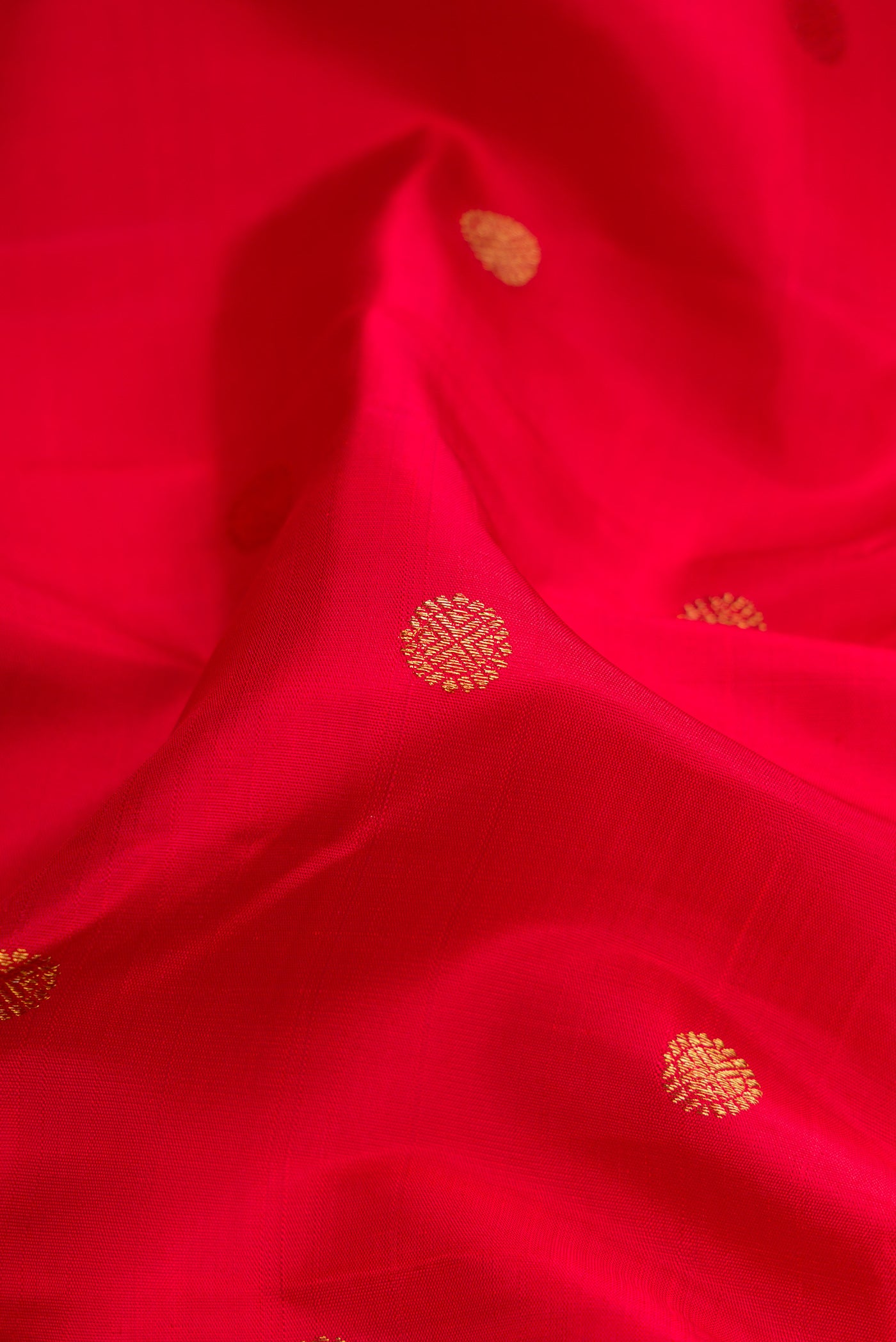 Close up of Red Dual Tone Kanjivaram Silk Saree with Zari Butta on the body and Ganga Jamuna Border.  displaying folds
