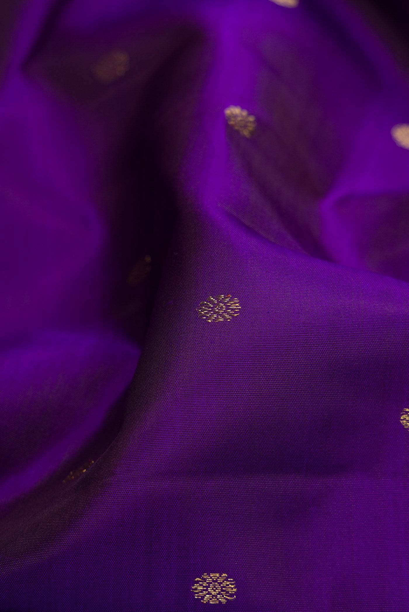 Close up of Pure Silk Pure Zari Royal Blue Dual Tone Kanchipuram Saree with Zari Butta on the body and Zari Border.  displaying folds
