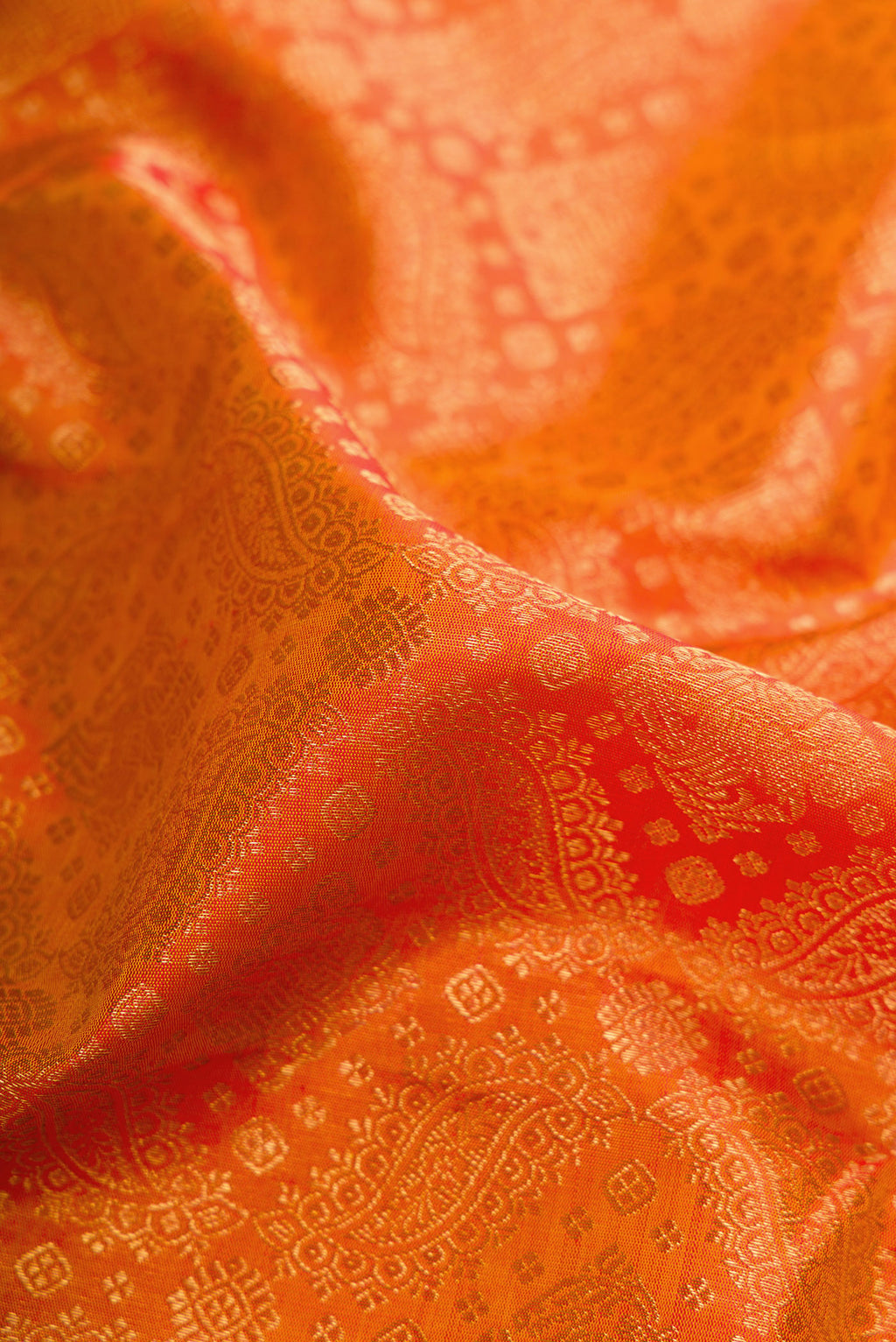 Close up of Pure Silk Pure Zari Orange Kanjivaram Saree with Zari Brocade on the body and Zari Border.  displaying folds