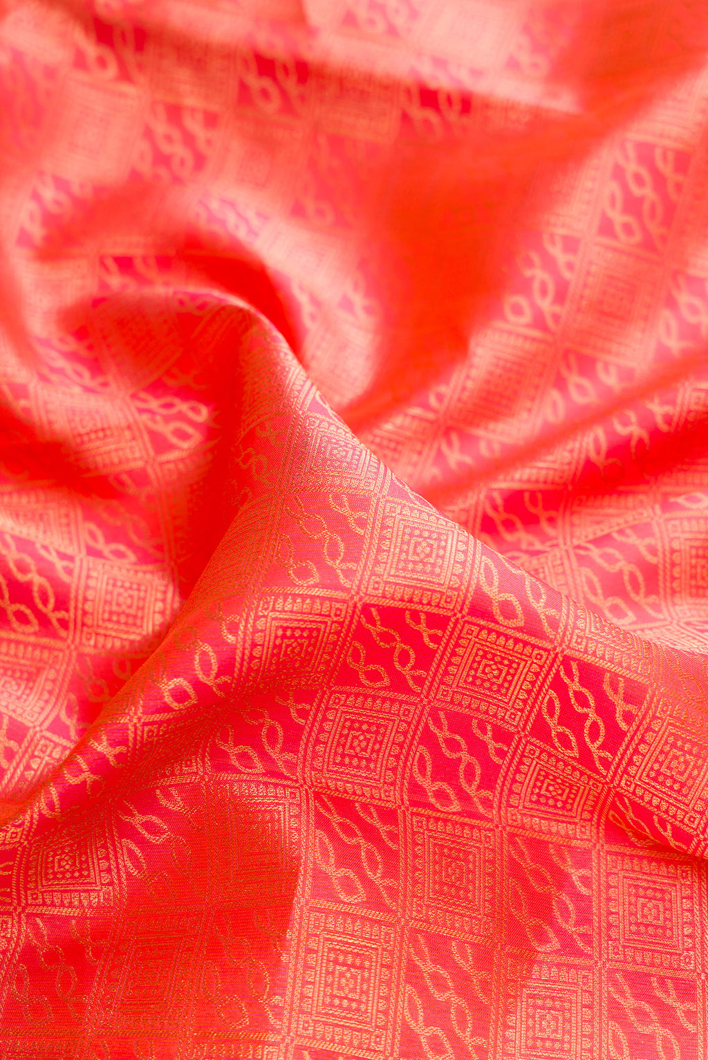 Close up of Pure Silk Brick Orange Dual Tone Kanchipuram Saree with Zari Brocade on the body and Zari Border.  displaying folds