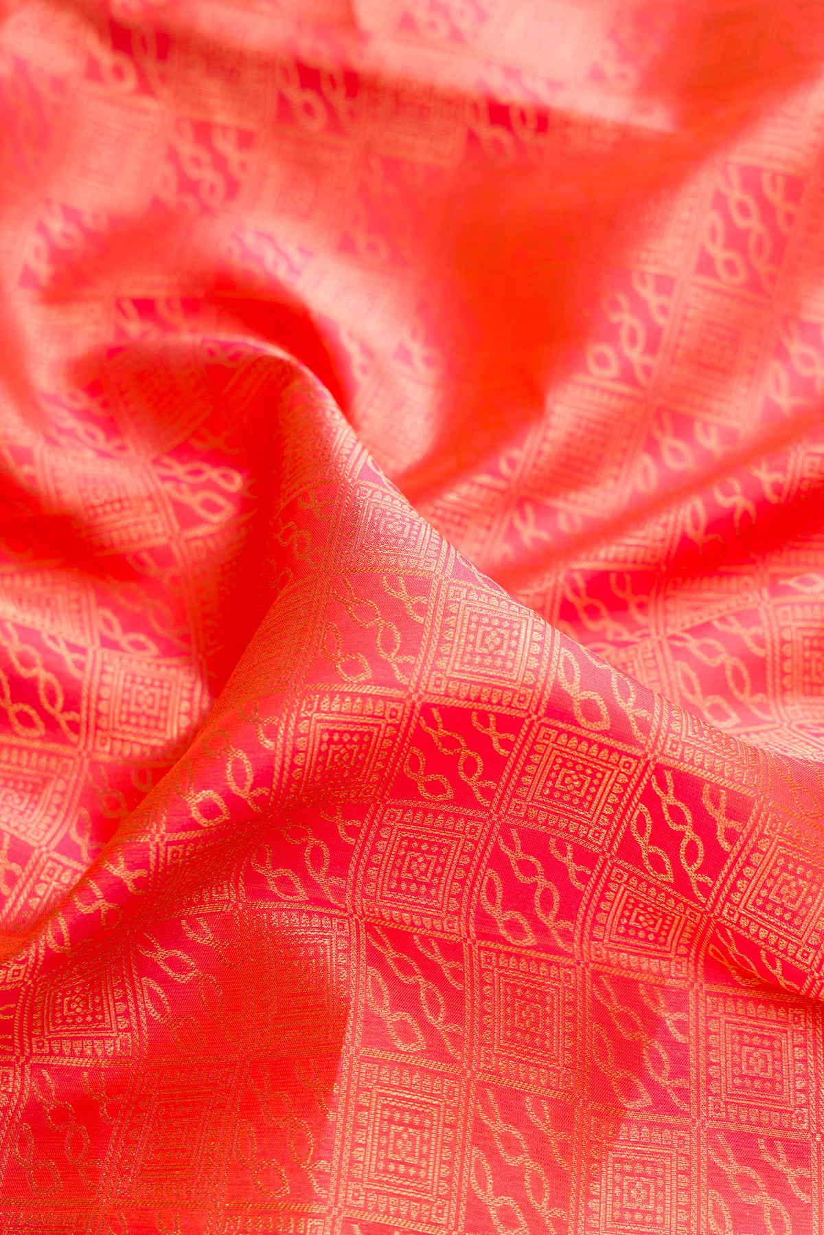Close up of Pure Silk Brick Orange Dual Tone Kanchipuram Saree with Zari Brocade on the body and Zari Border.  displaying folds