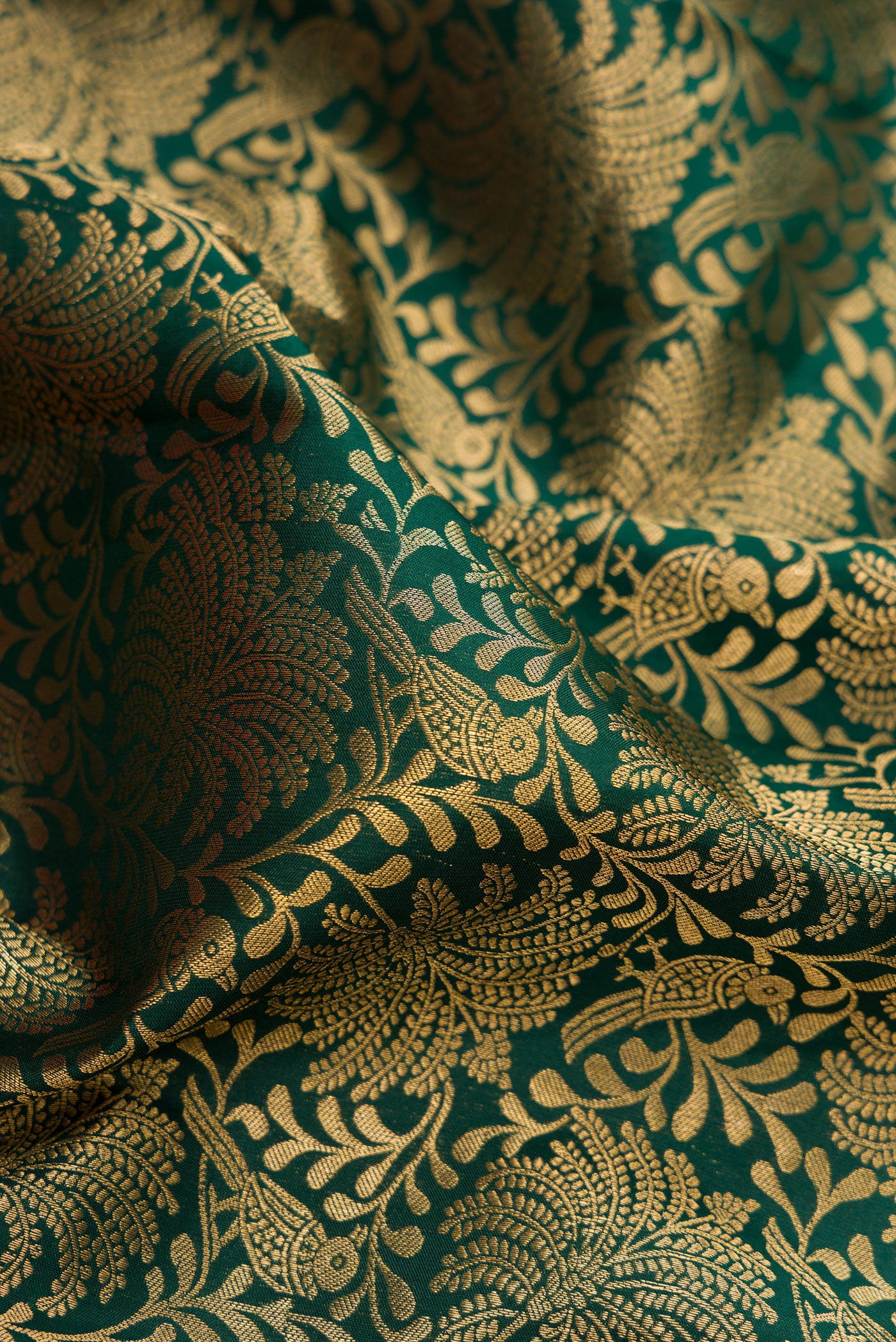 Close up of Bottle Green Kanjivaram Silk Saree with Zari Brocade on the body and Zari Border.  displaying folds