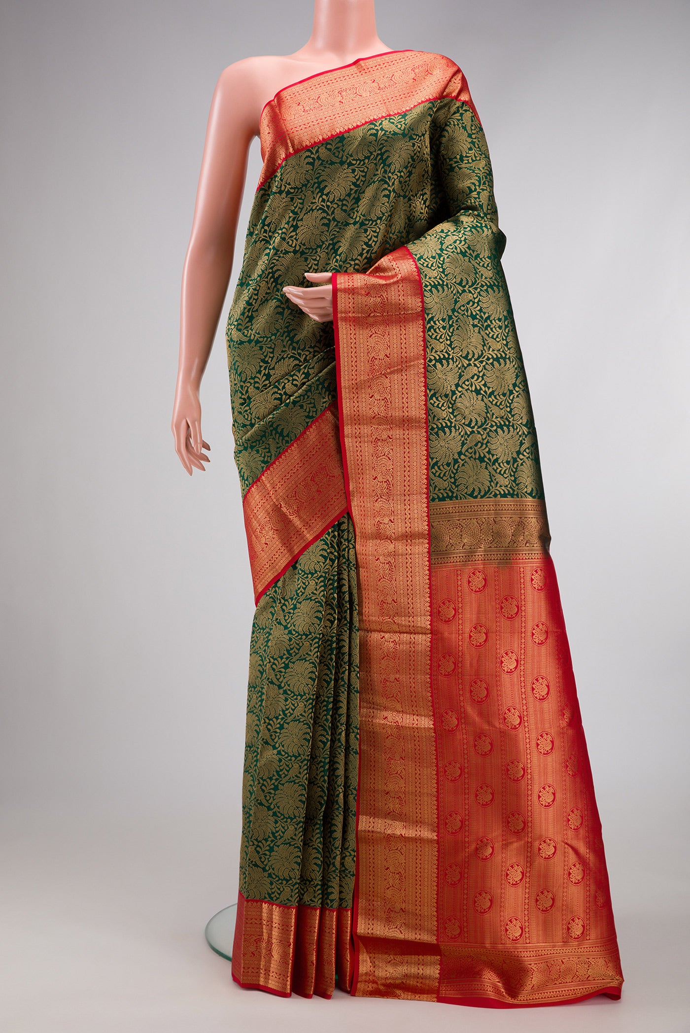 Bottle Green Kanjivaram Silk Saree with Zari Brocade on the body and Zari Border.  displayed on a mannequin