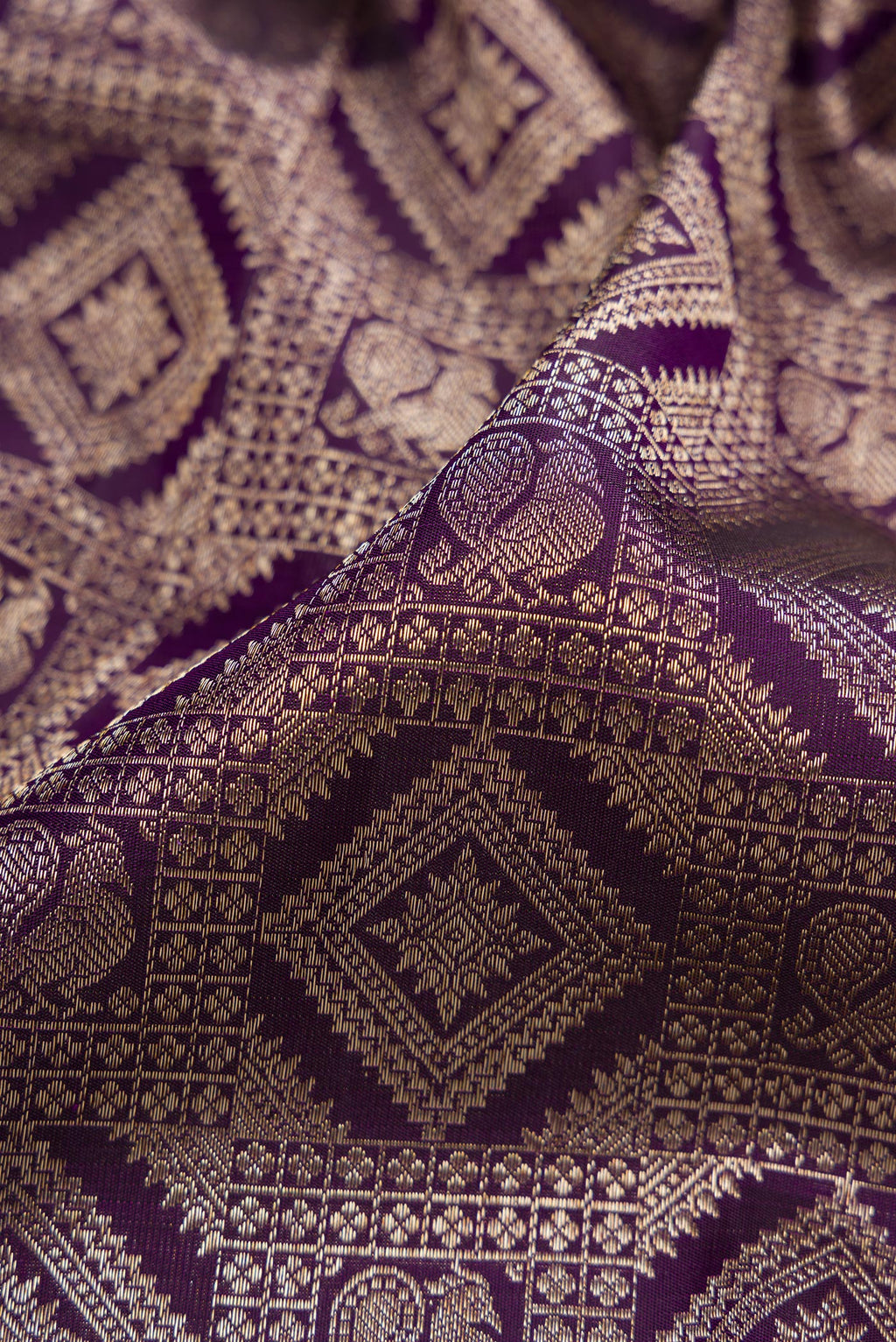 Close up of Violet Kanchipuram Silk Saree with Zari Brocade on the body and Zari Border.  displaying folds