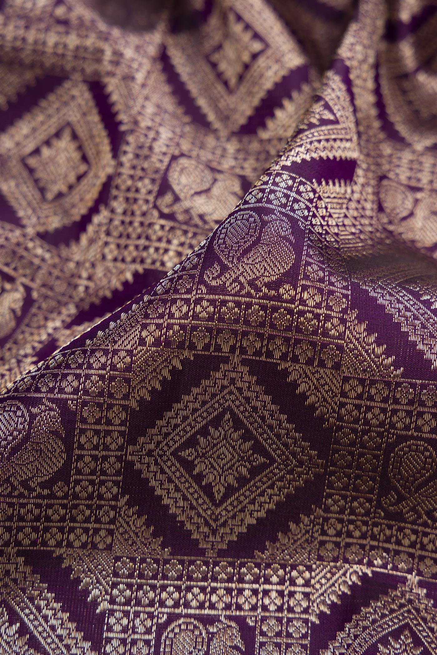Close up of Violet Kanchipuram Silk Saree with Zari Brocade on the body and Zari Border.  displaying folds