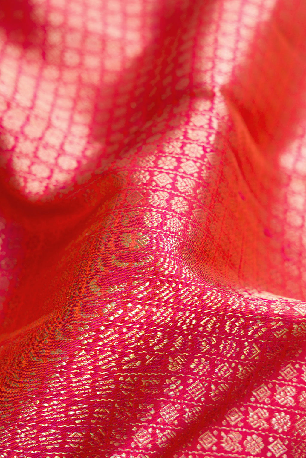 Close up of Coral Dual Tone Kanchipuram Silk Saree with Zari Brocade on the body and Zari Border.  displaying folds