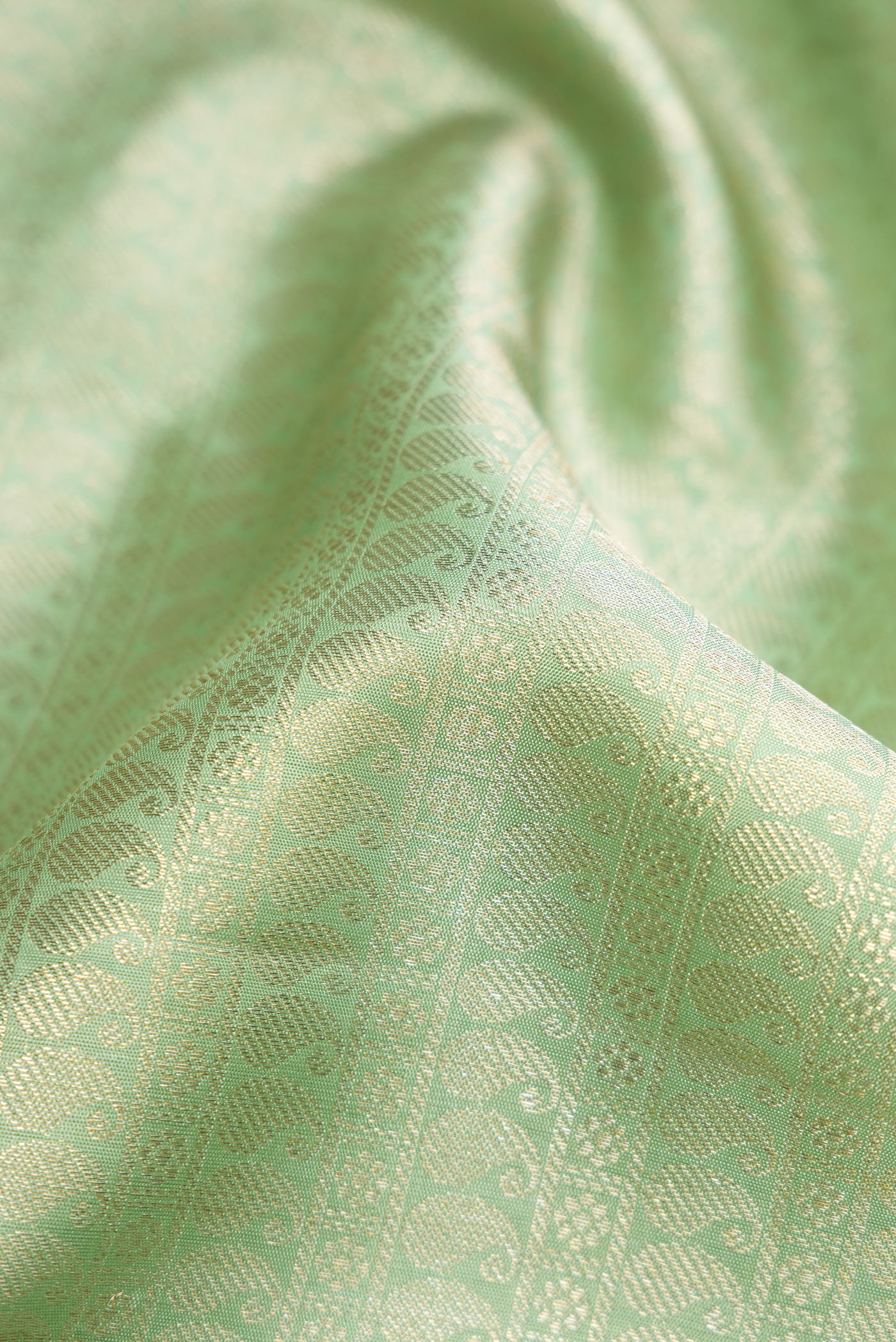 Close up of Pista Green Dual Tone Kanchipuram Silk Saree with Zari Brocade on the body and Zari Border.  displaying folds