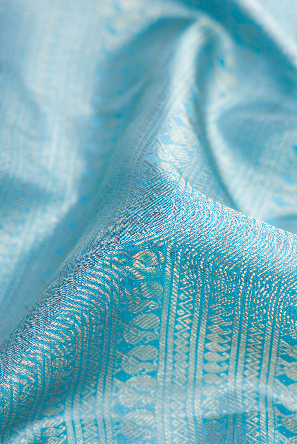 Close up of Sky Blue Kanchipuram Silk Saree with Zari Brocade on the body and Zari Border.  displaying folds