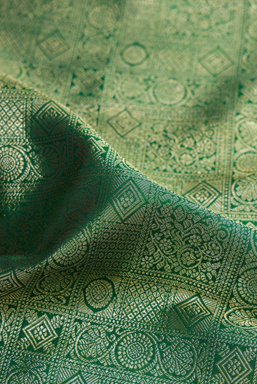 Close up of Green Kanchipuram Silk Saree with Zari Brocade on the body and Zari Border.  displaying folds