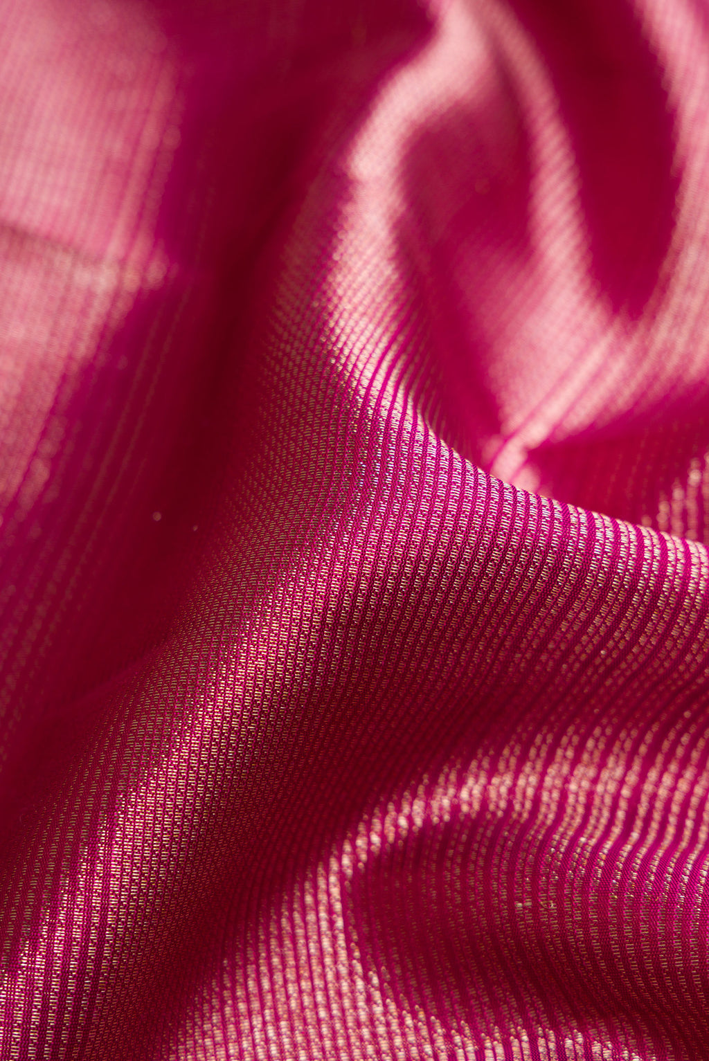 Close up of Magenta Kanchipuram Silk Saree with Zari Brocade on the body and Zari Border.  displaying folds