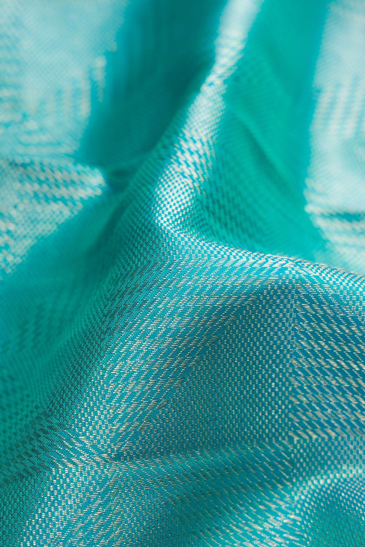 Close up of Turquoise Dual Tone Kanchipuram Silk Saree with Zari Brocade on the body and Zari Border.  displaying folds