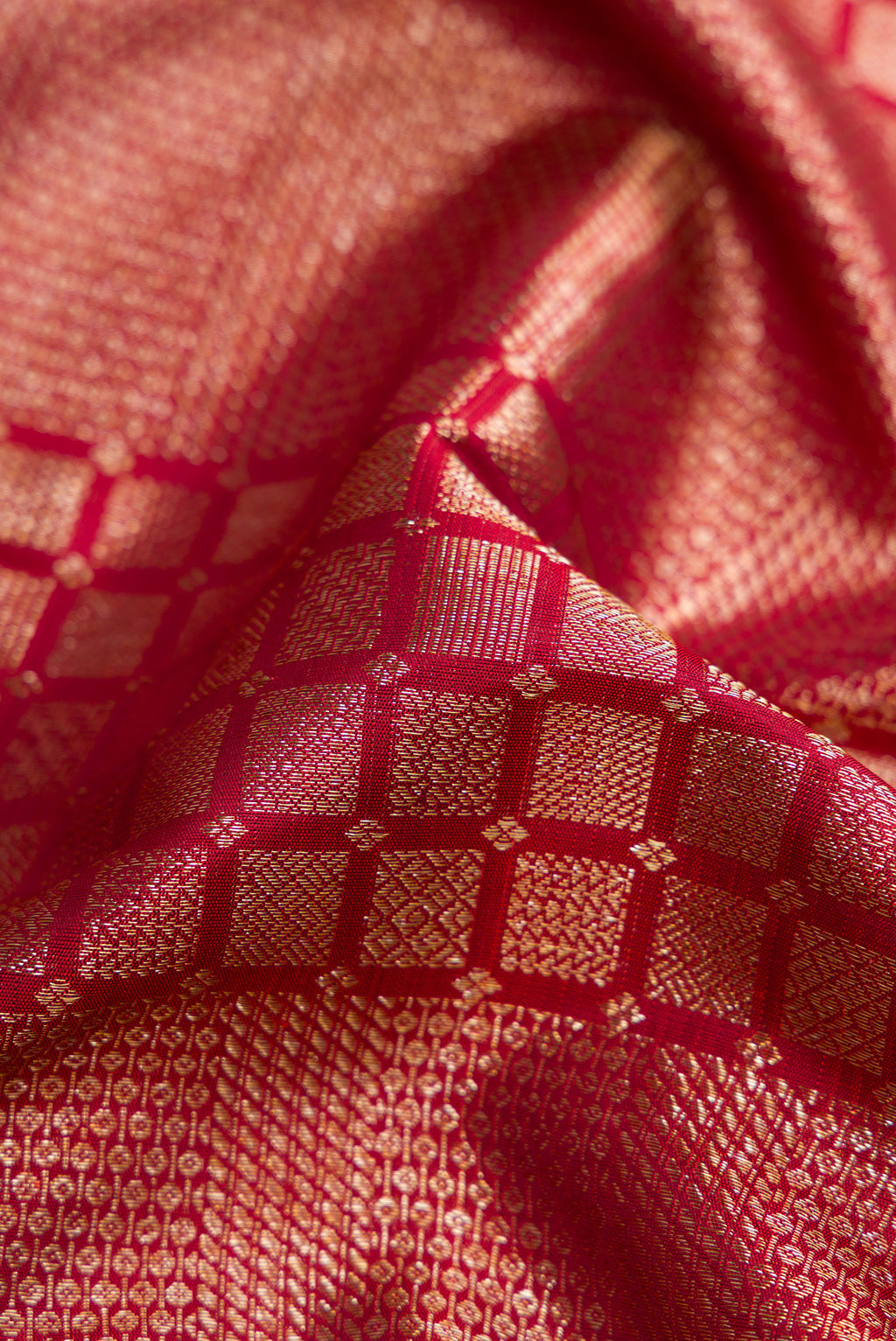 Close up of Maroon Kanchipuram Silk Saree with Zari Brocade on the body and Zari Border.  displaying folds