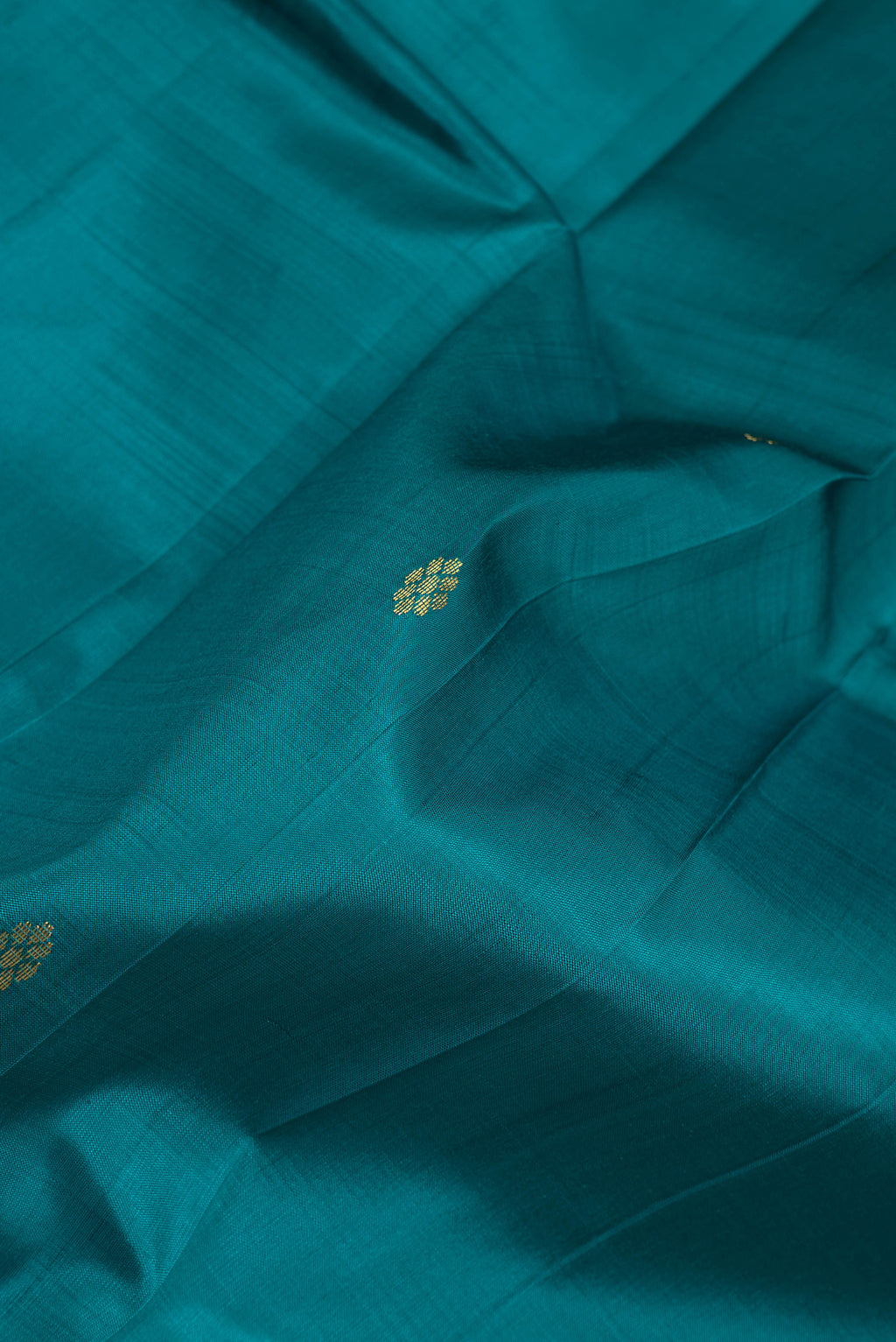 Close up of Peacock Blue Dual Tone Kanjivaram Silk Saree with Zari Butta on the body and One Side Border.  displaying folds