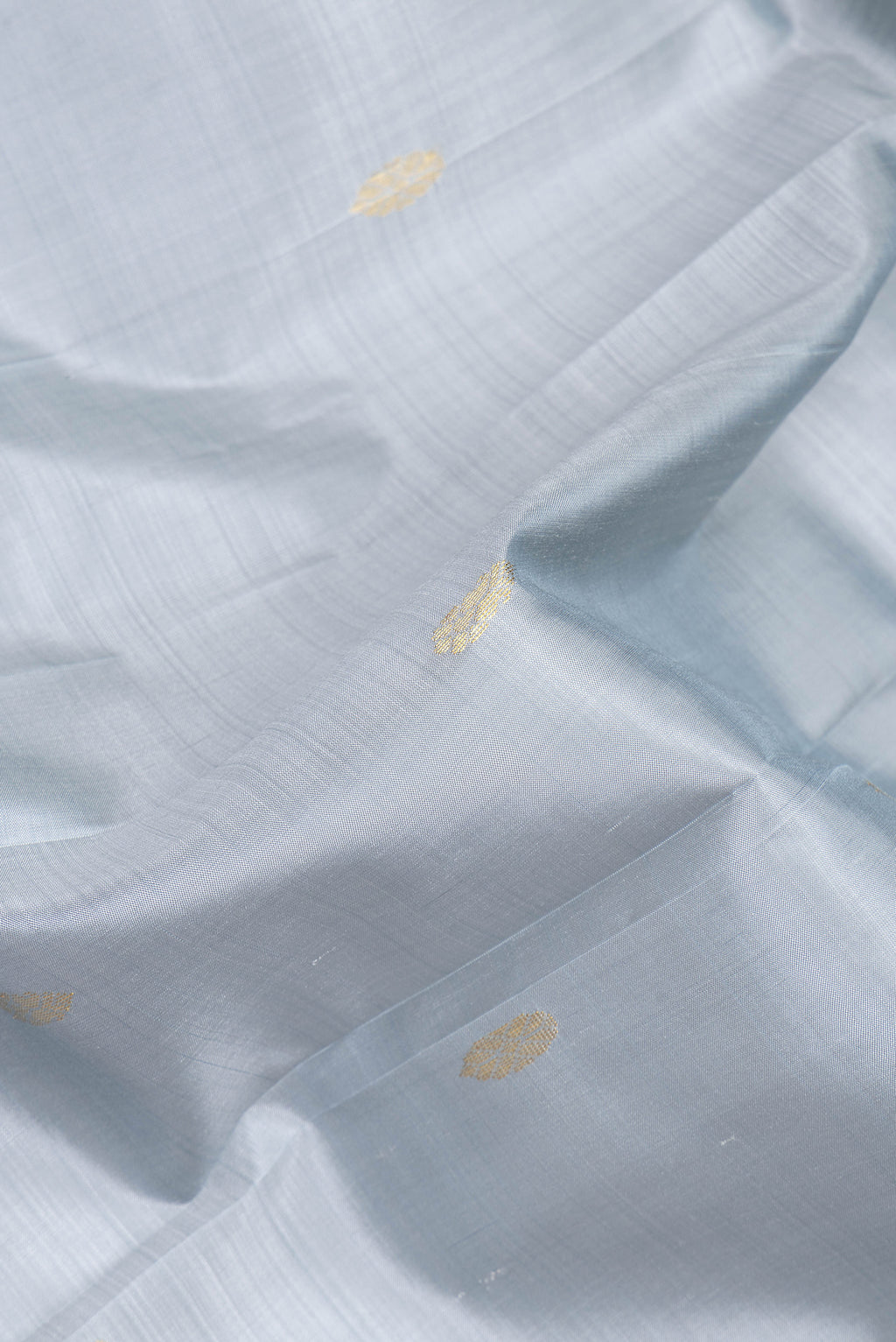 Close up of Grey Kanjivaram Silk Saree with Zari Butta on the body and One Side Border.  displaying folds