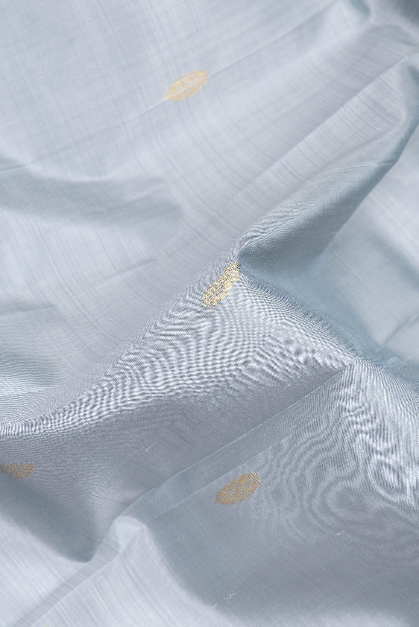 Close up of Grey Kanjivaram Silk Saree with Zari Butta on the body and One Side Border.  displaying folds