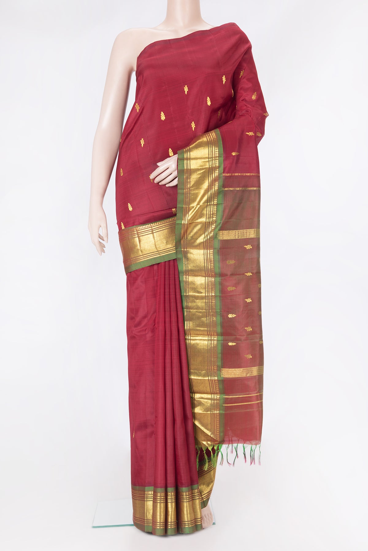 Maroon Kanjivaram Silk Saree with Zari Butta on the body and One Side Border.  displayed on a mannequin