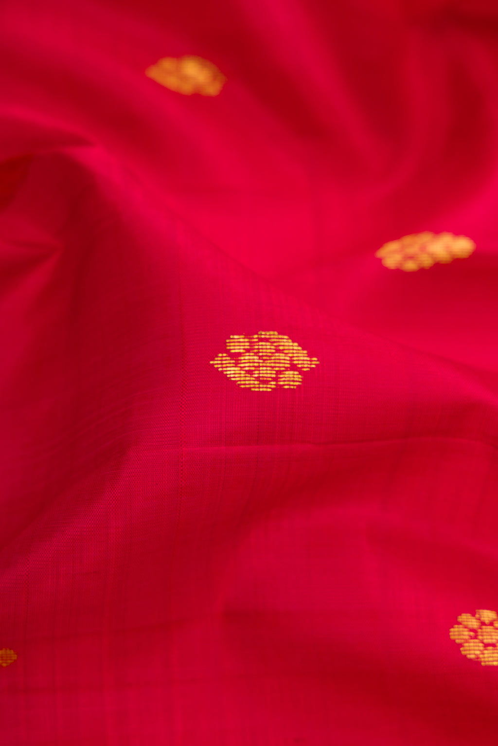 Close up of Maroon Kanjivaram Silk Saree with Zari Butta on the body and One Side Border.  displaying folds