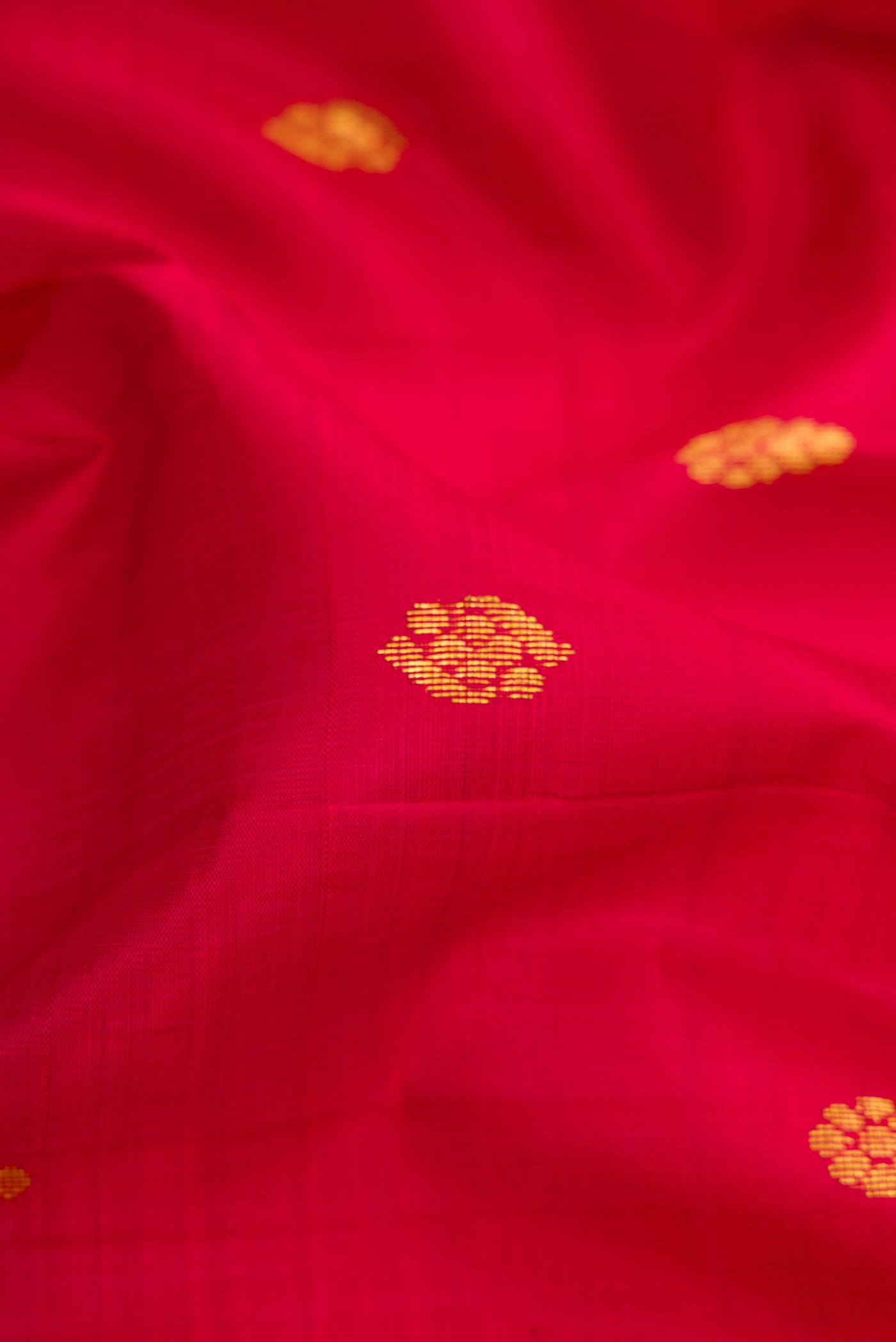 Close up of Maroon Kanjivaram Silk Saree with Zari Butta on the body and One Side Border.  displaying folds