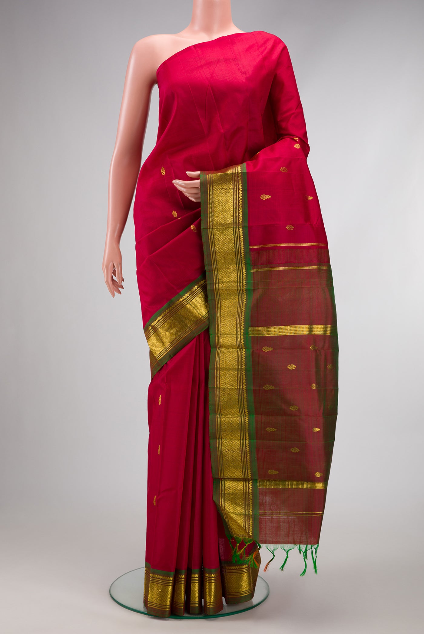 Maroon Kanjivaram Silk Saree with Zari Butta on the body and One Side Border.  displayed on a mannequin