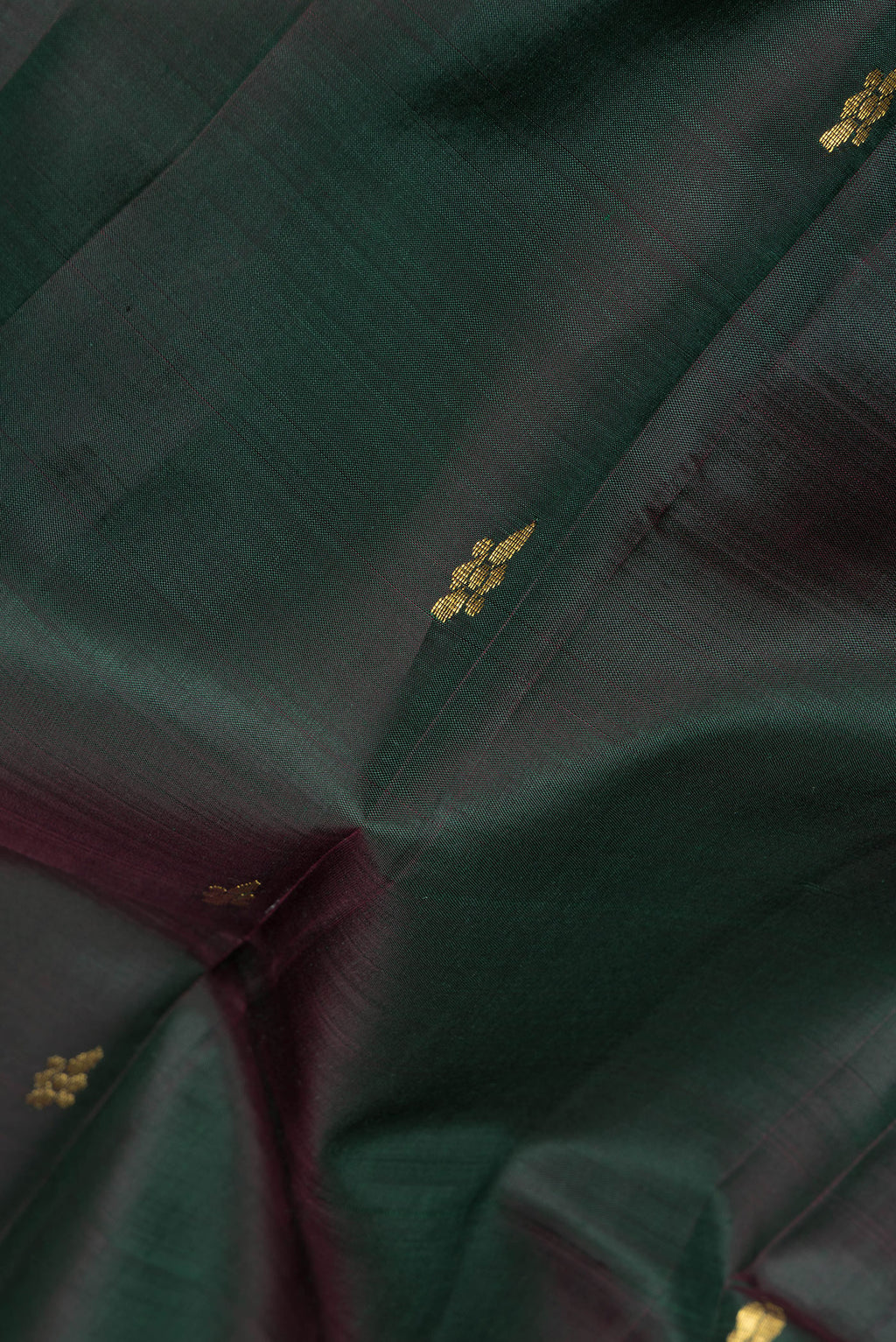 Close up of Bottle Green Kanjivaram Silk Saree with Zari Butta on the body and One Side Border.  displaying folds