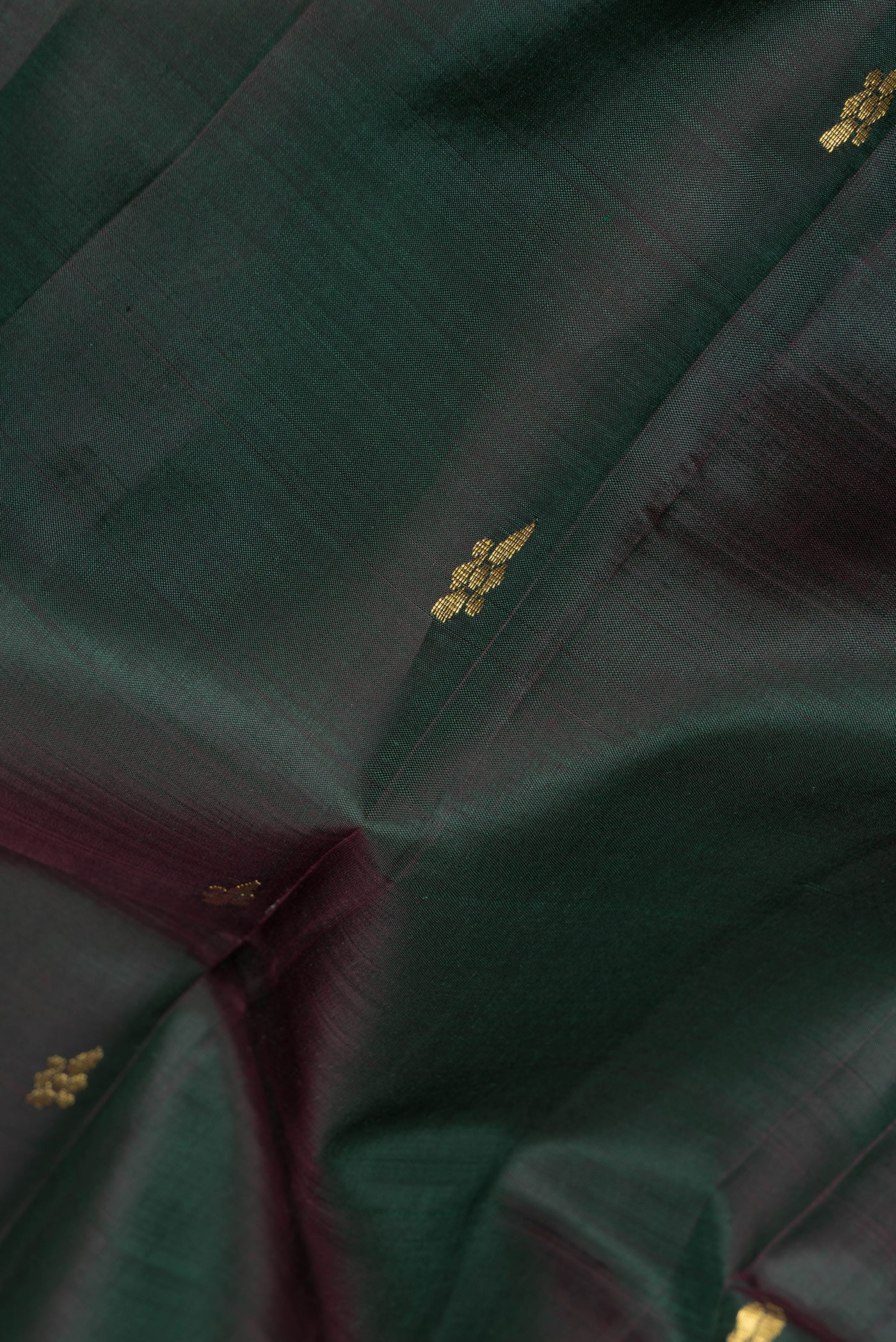 Close up of Bottle Green Kanjivaram Silk Saree with Zari Butta on the body and One Side Border.  displaying folds