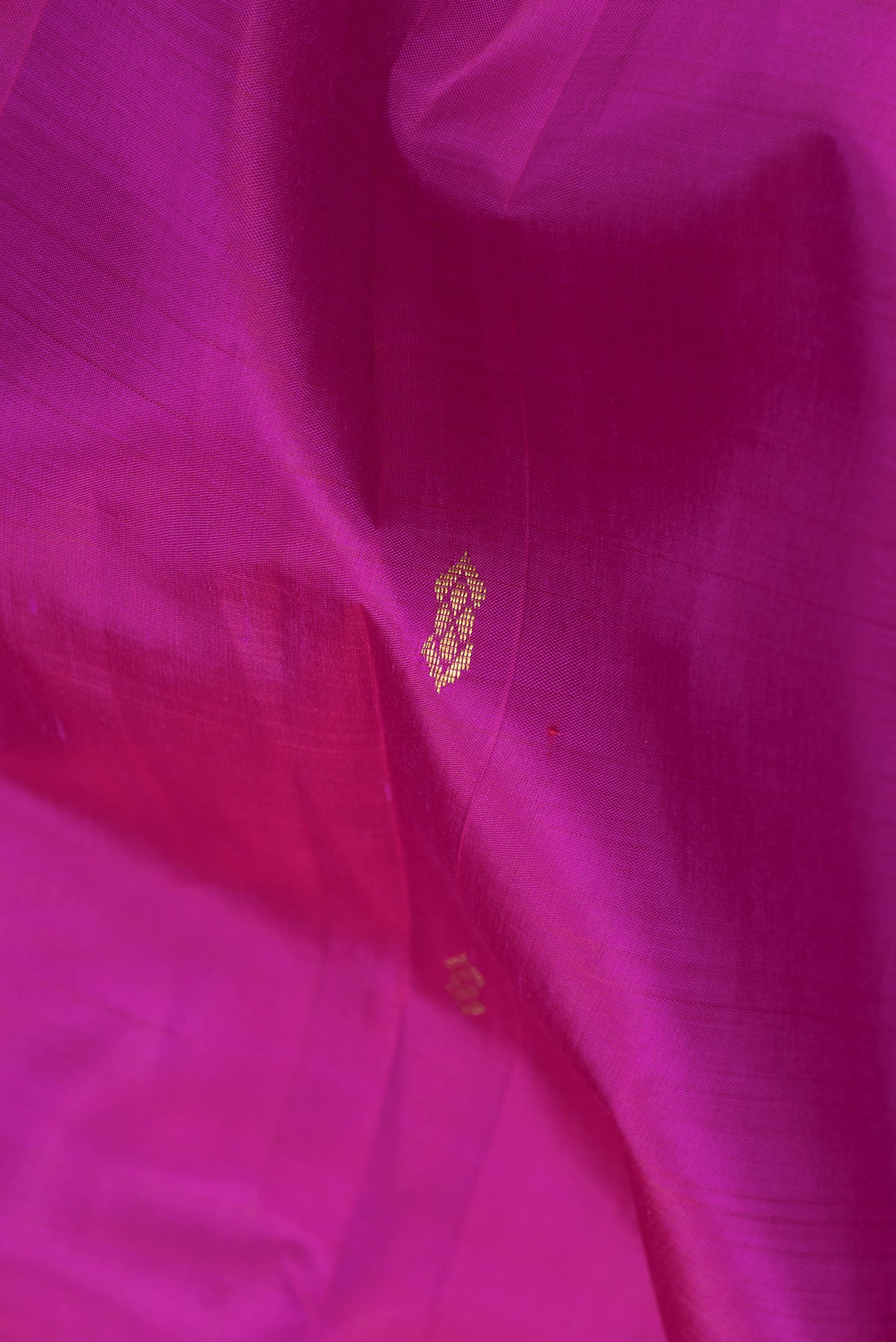 Close up of Magenta Kanjivaram Silk Saree with Zari Butta on the body and One Side Border.  displaying folds