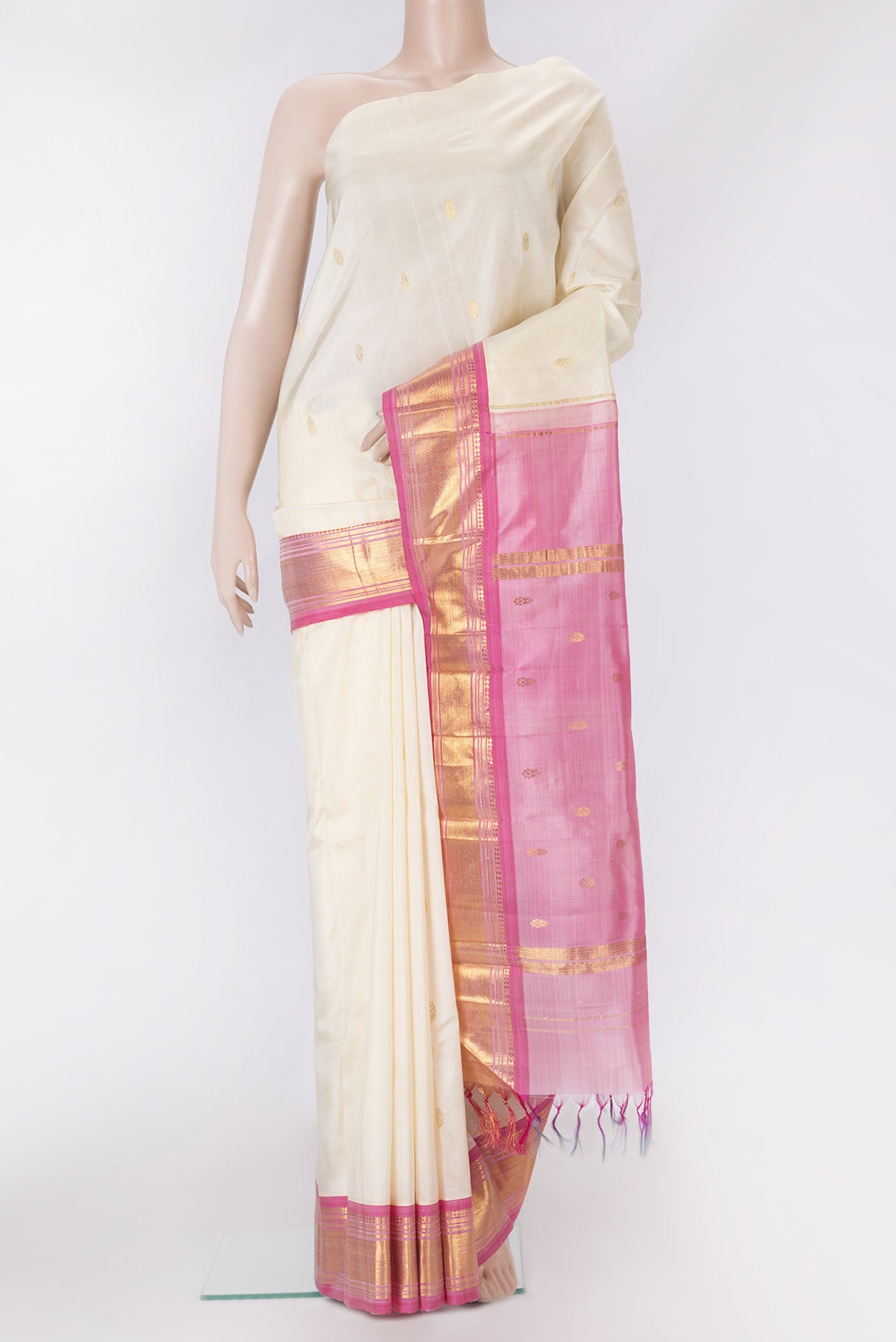 Off White Kanjivaram Silk Saree with Zari Butta on the body and One Side Border.  displayed on a mannequin