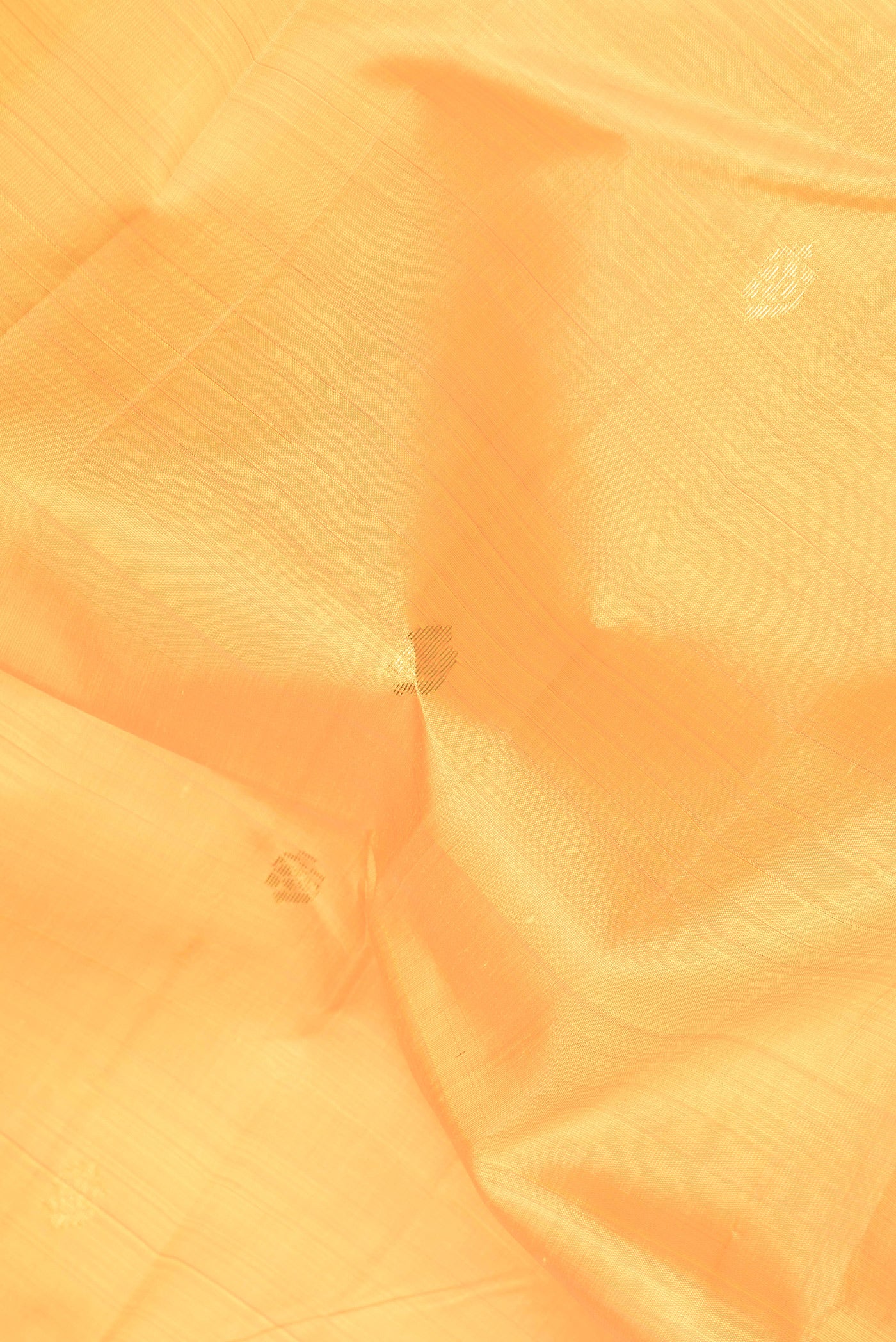 Close up of Yellow Dual Tone Kanjivaram Silk Saree with Zari Butta on the body and Zari Border.  displaying folds