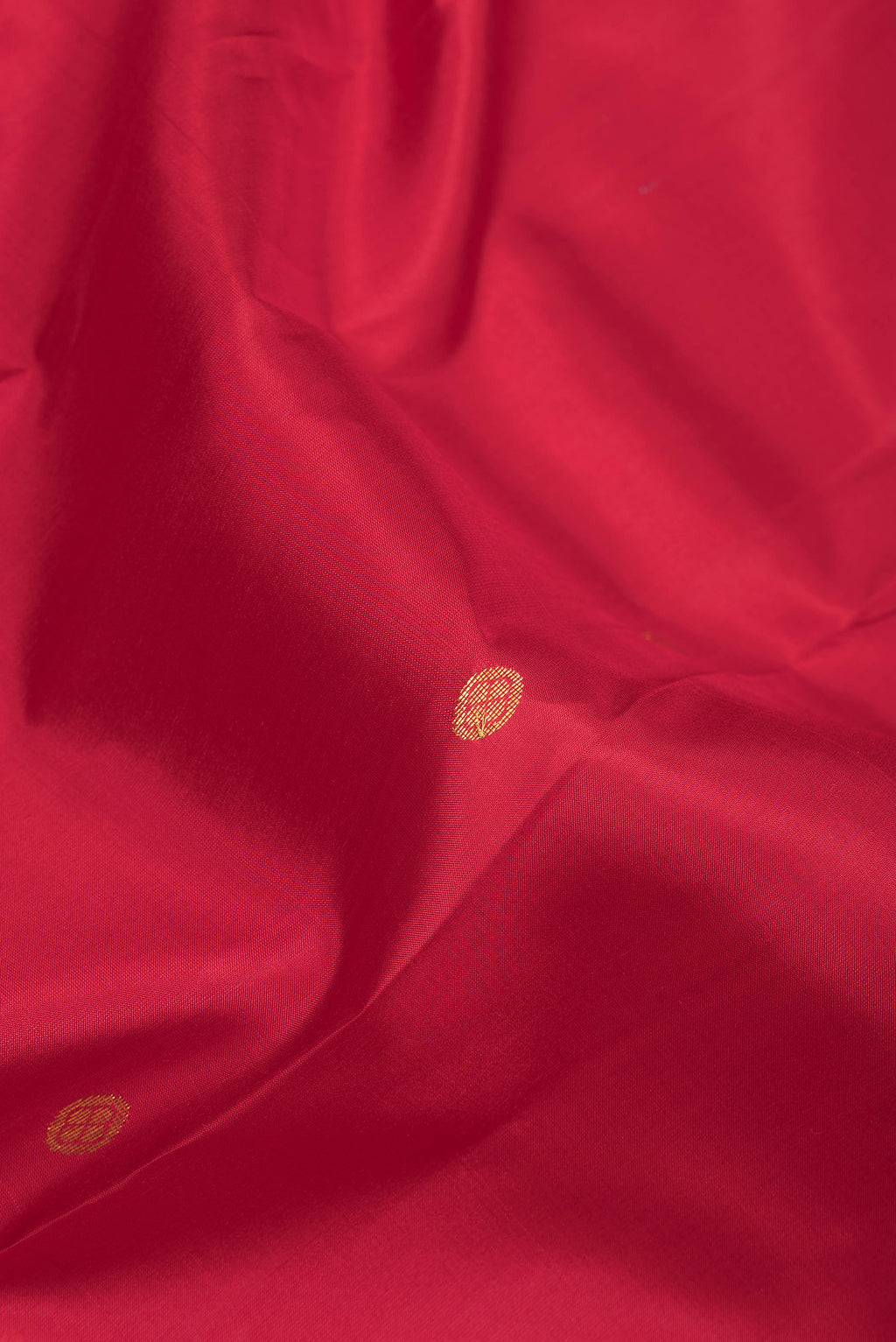 Close up of Red Kanchipuram Silk Saree with Zari Butta on the body and Zari Border.  displaying folds
