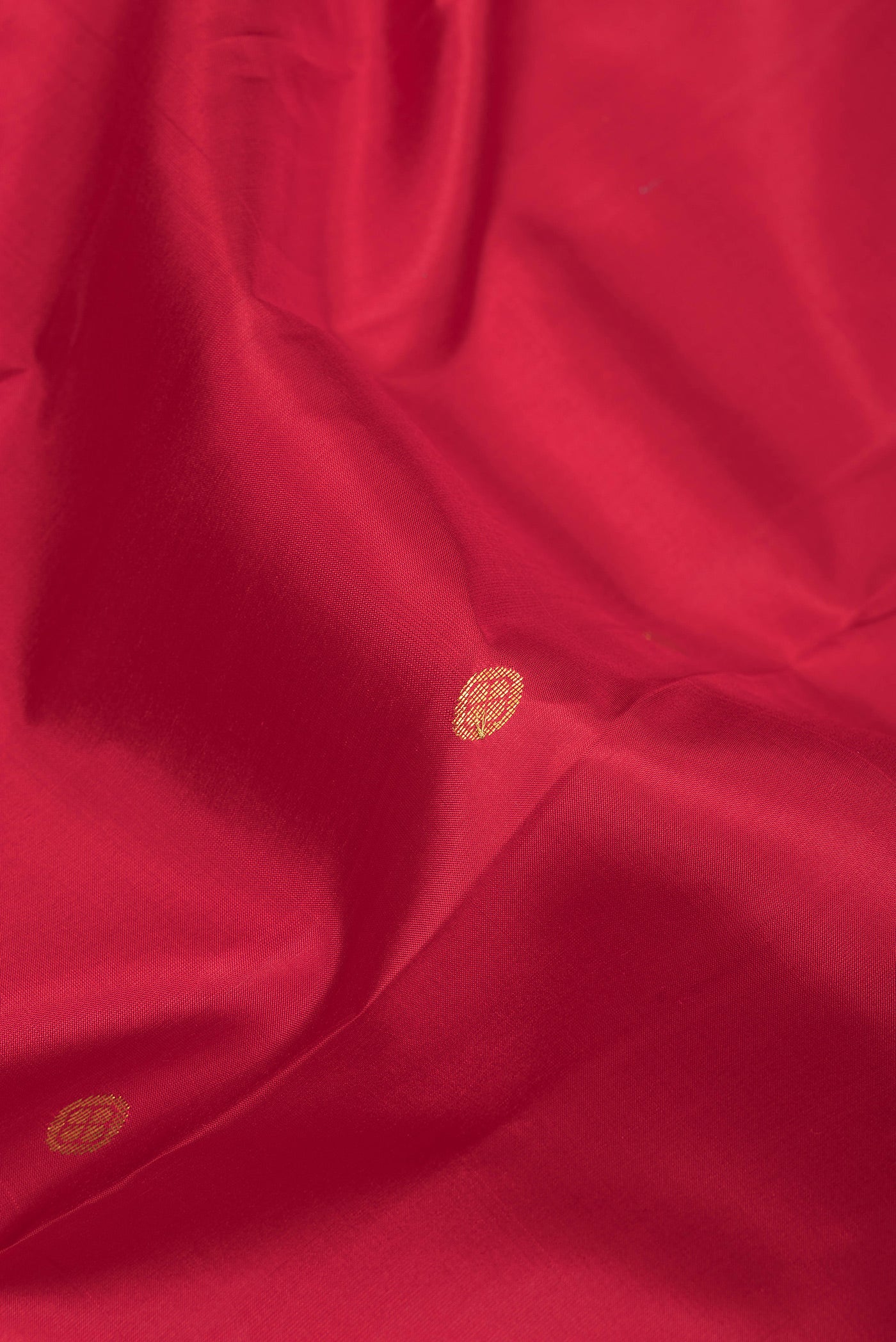 Close up of Red Kanchipuram Silk Saree with Zari Butta on the body and Zari Border.  displaying folds