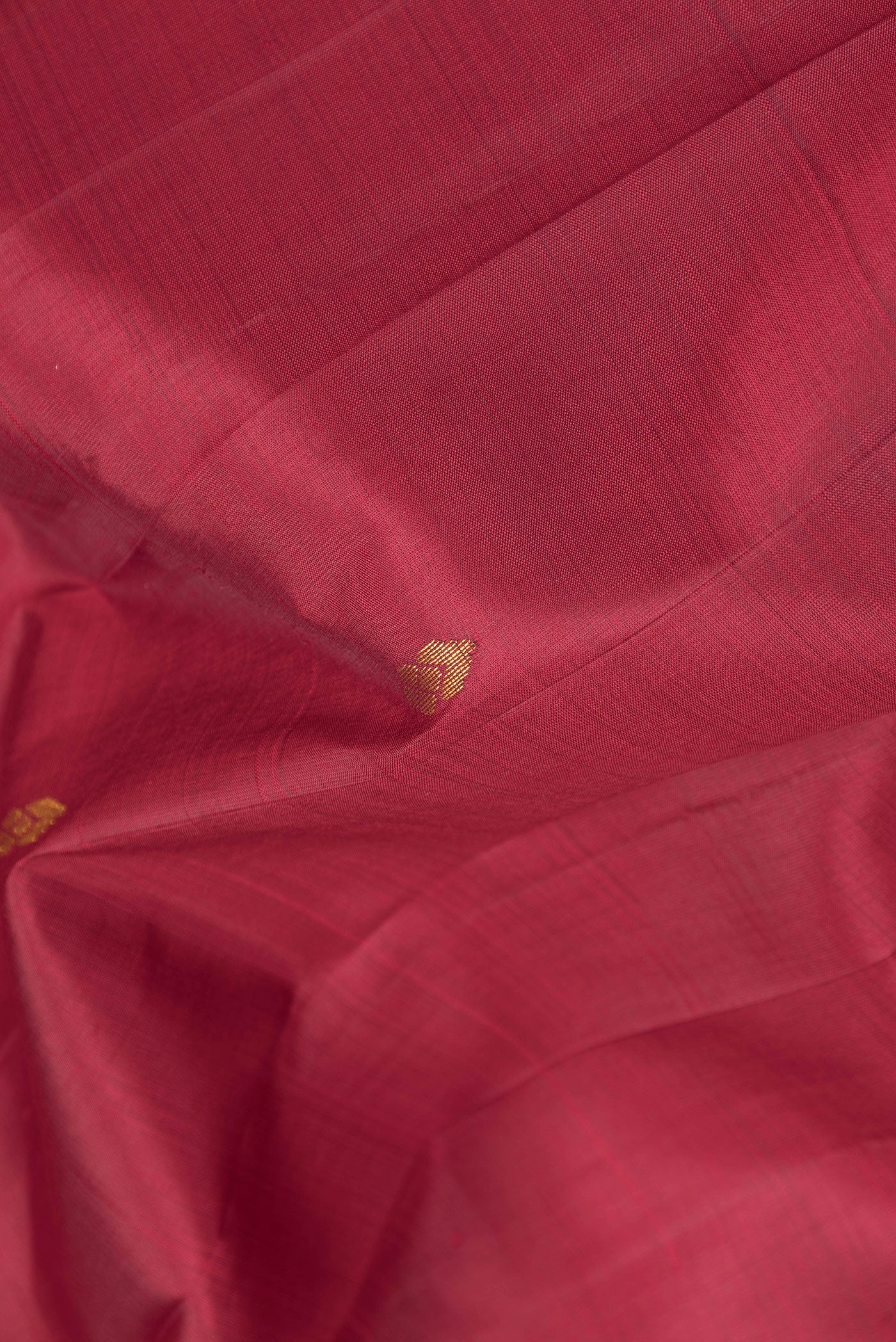 Close up of Maroon Kanjivaram Silk Saree with Zari Butta on the body and One Side Border.  displaying folds
