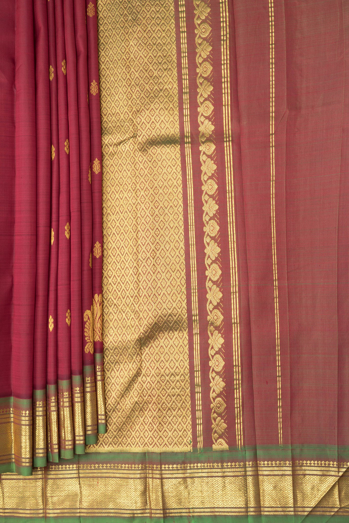 Pleats and pallu of Maroon Kanjivaram Silk Saree with Zari Butta on the body and One Side Border. 