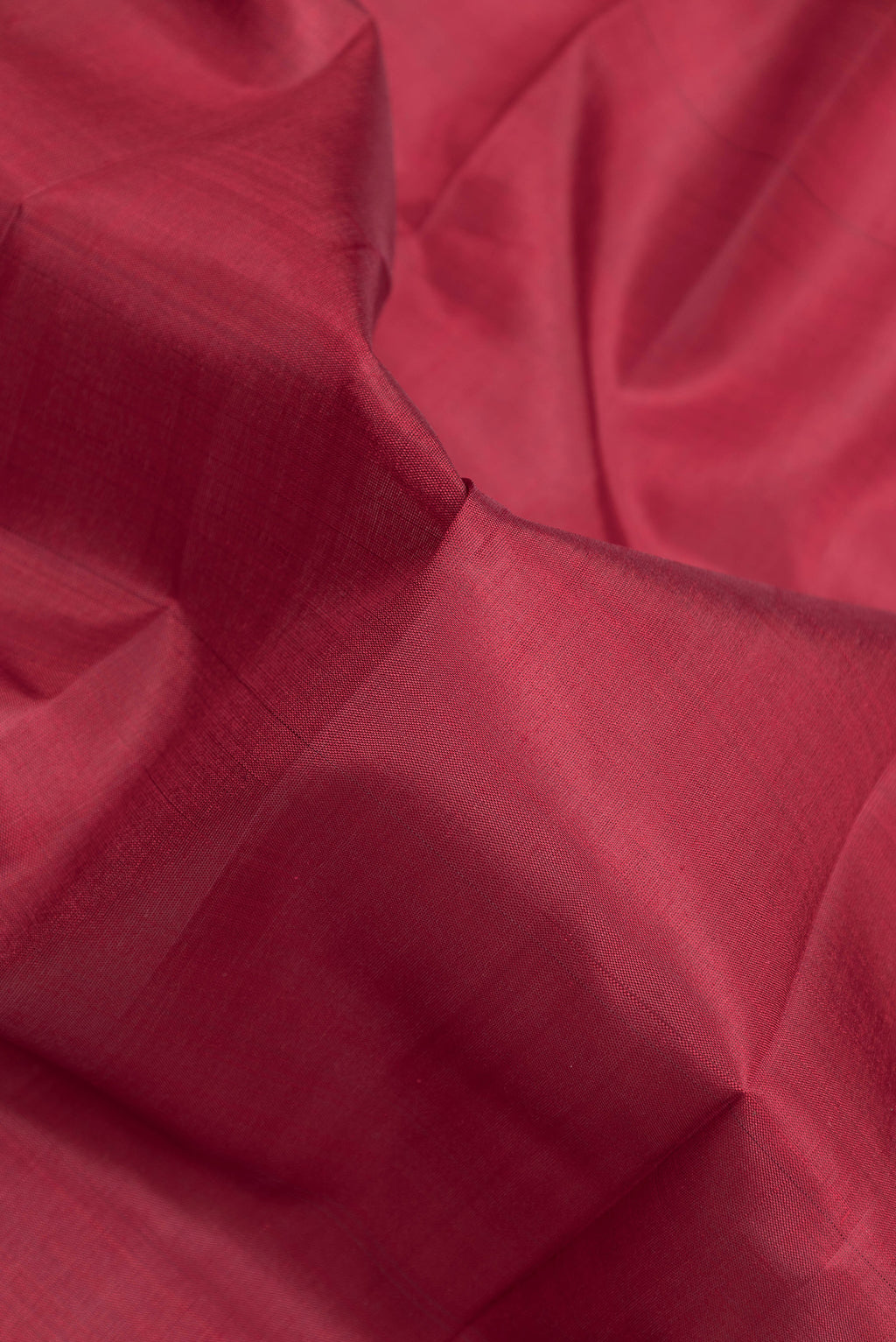 Close up of Maroon Kanjivaram Silk Saree with Plain Body and Zari Border.  displaying folds
