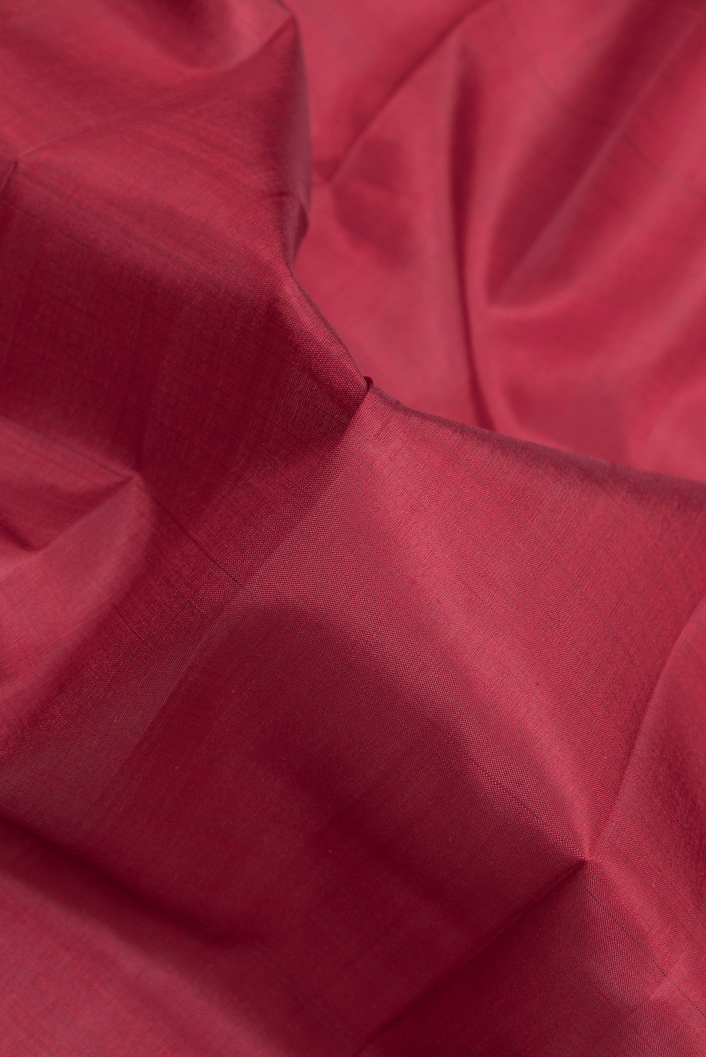 Close up of Maroon Kanjivaram Silk Saree with Plain Body and Zari Border.  displaying folds